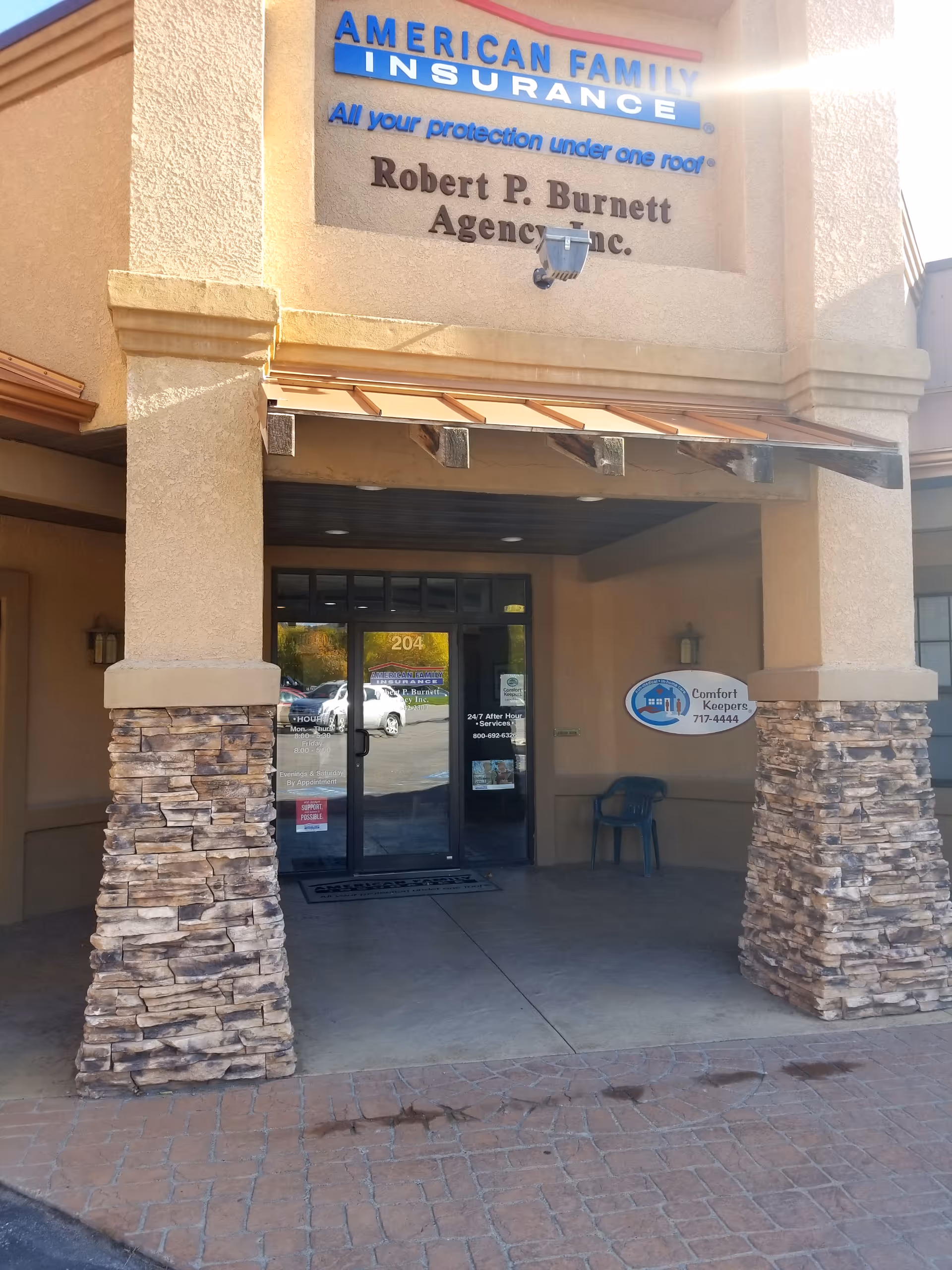 Entrance to Comfort Keepers Home Care with stone pillars and glass doors.