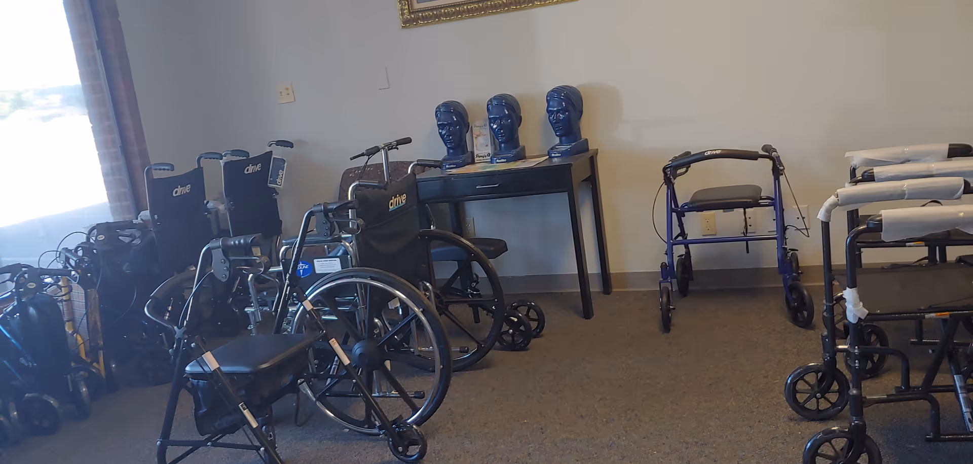 Interior room filled with wheelchairs, walkers, and therapy head mannequins.
