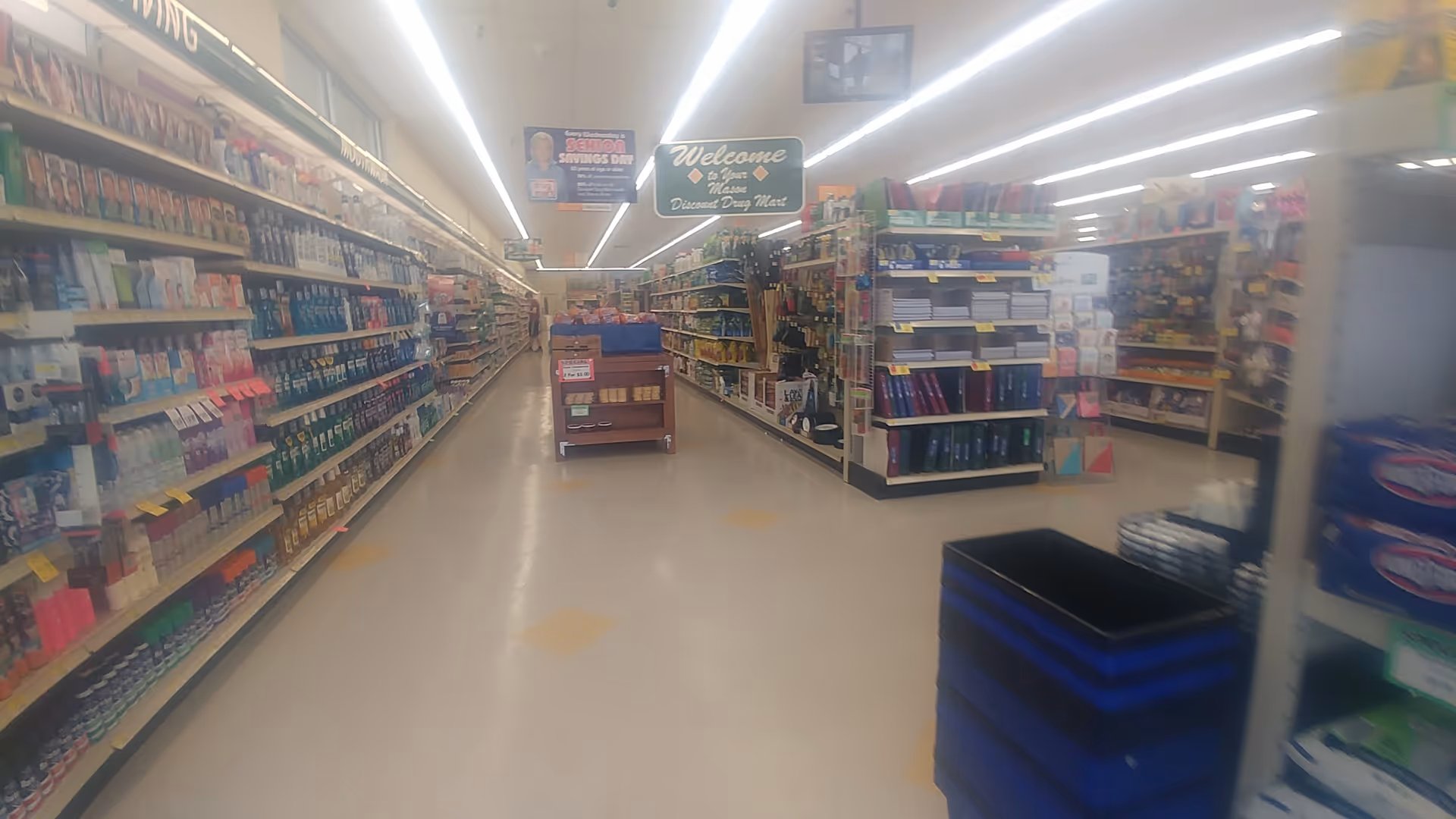 Aisle view inside a Discount Drug Mart store with shelves stocked on both sides.