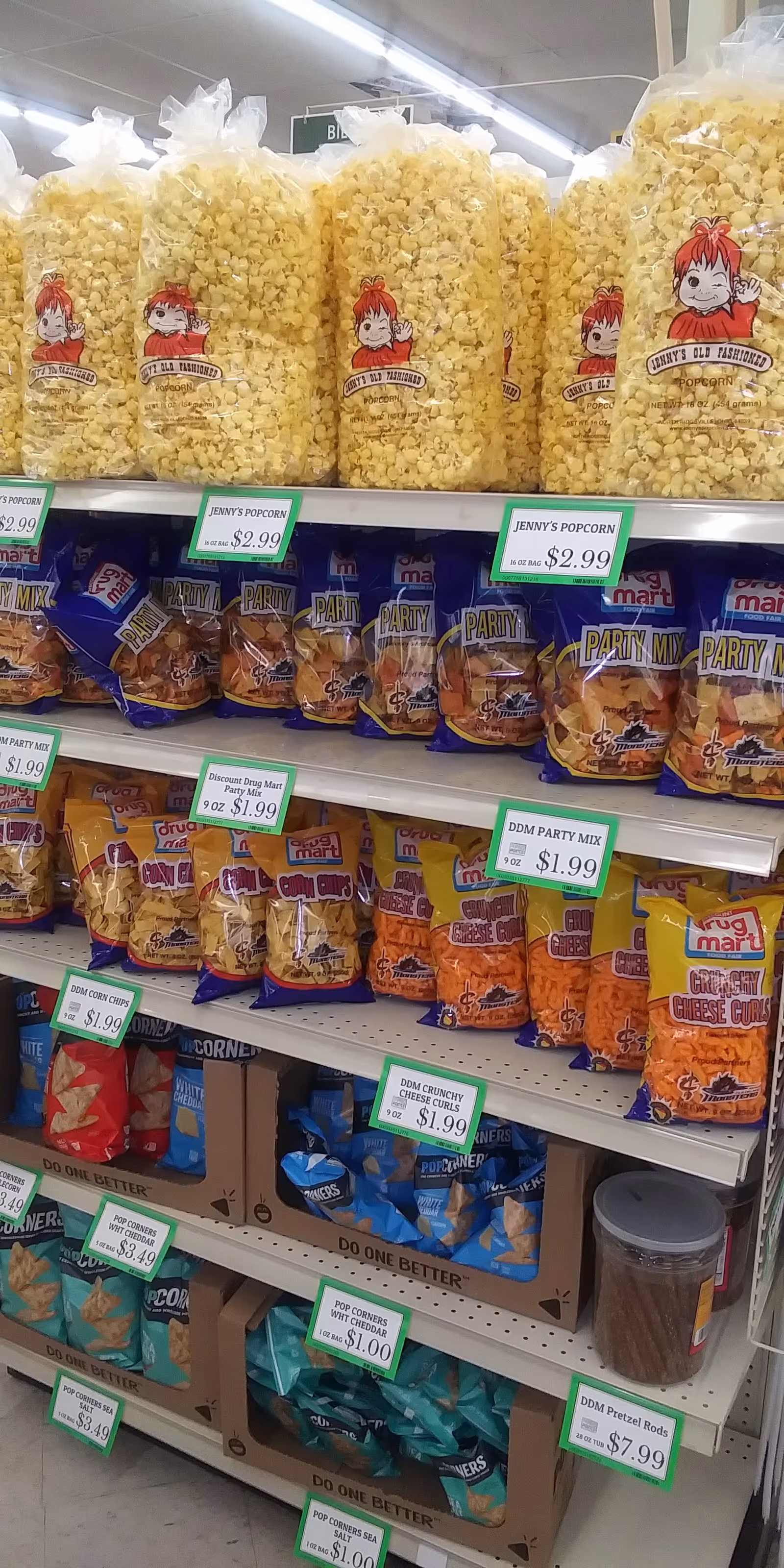 A grocery store aisle stocked with large bags of popcorn and snack mix