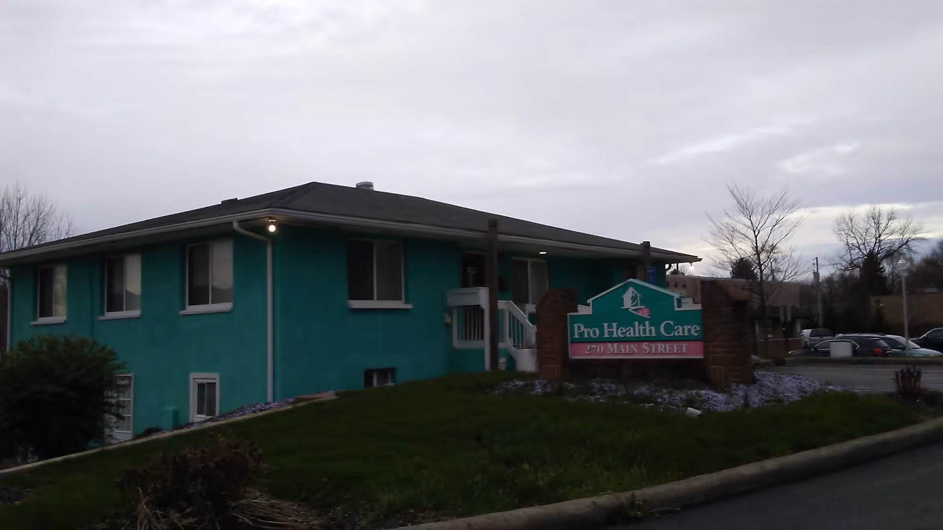 Turquoise single-story building with Pro Health Care sign and adjacent parking lot.