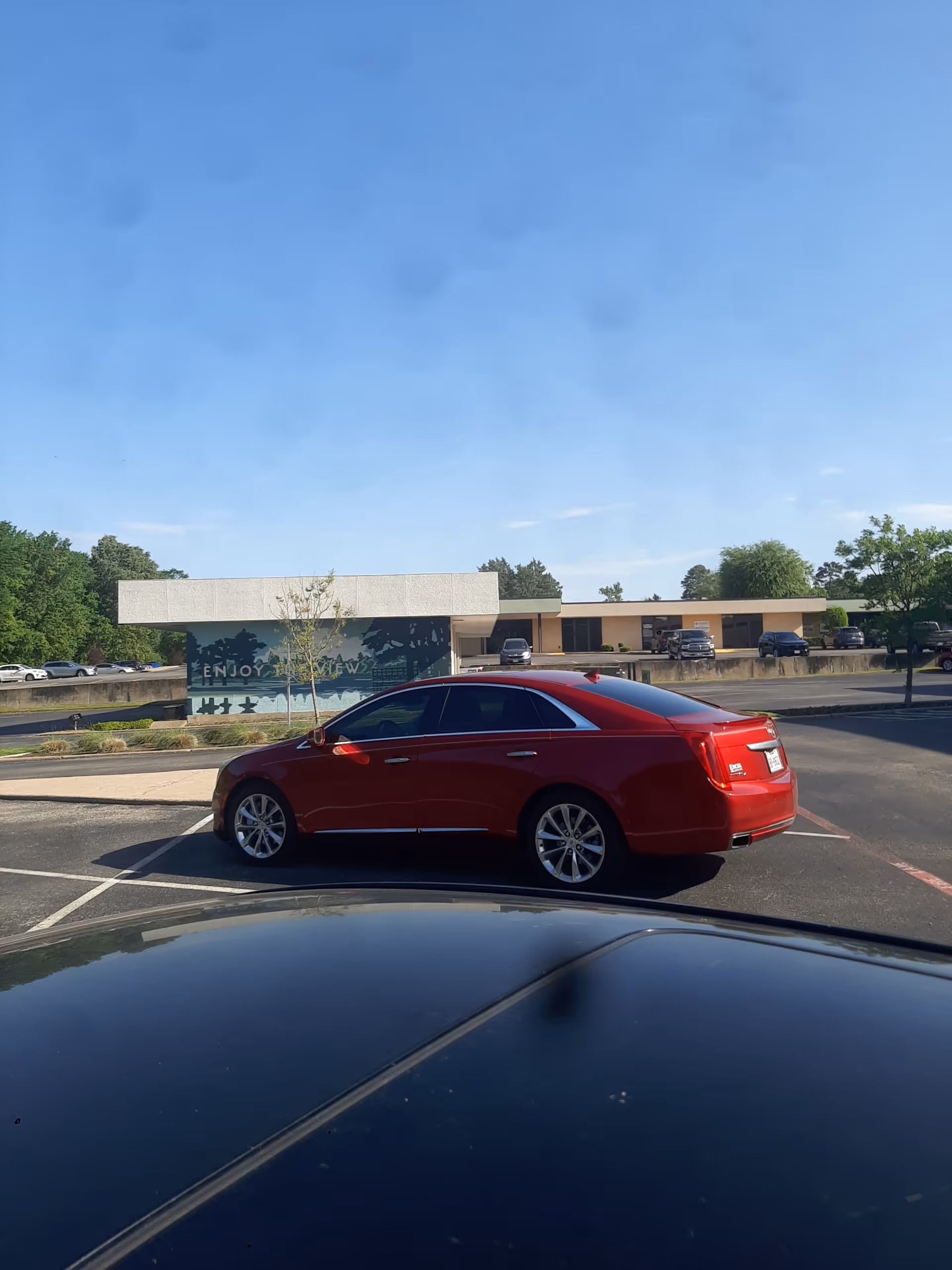 Red sedan parked in front of a single-story senior care facility exterior.
