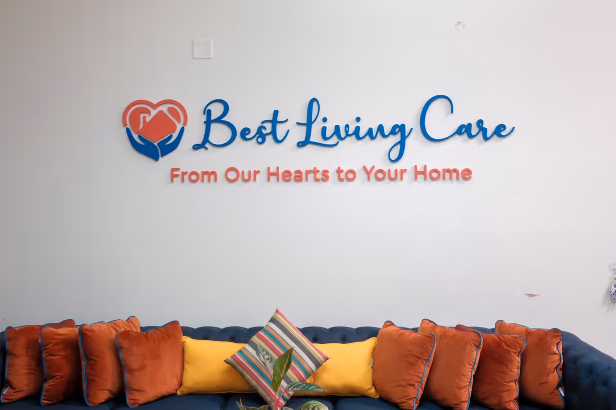 Interior lobby with Best Living Care logo and tagline on wall above a colorful sofa.