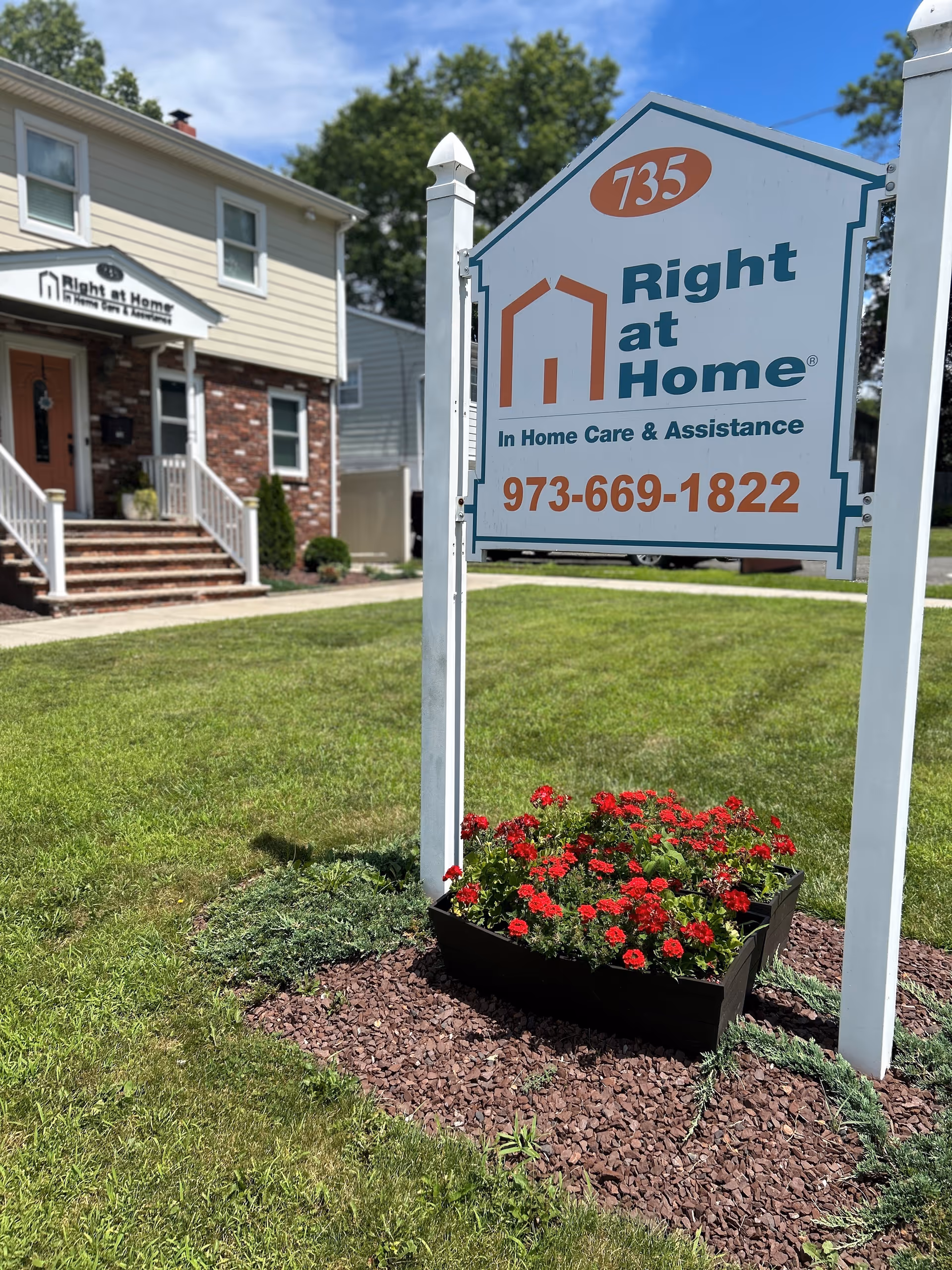Exterior view shows Right at Home sign, front lawn, and building entrance.