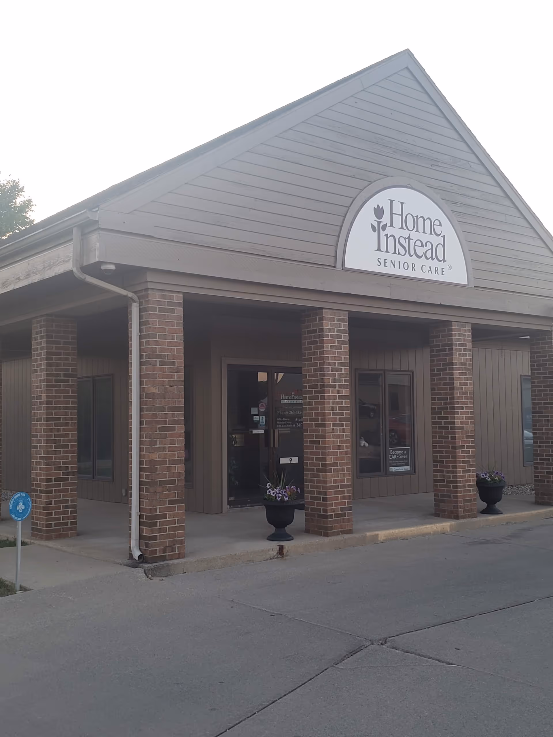 Front view of a Home Instead Senior Care building with brick columns and sign.