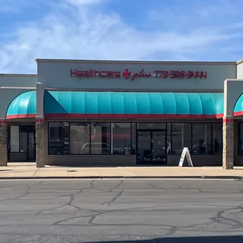 Front view of a healthcare facility with teal awning and glass storefront