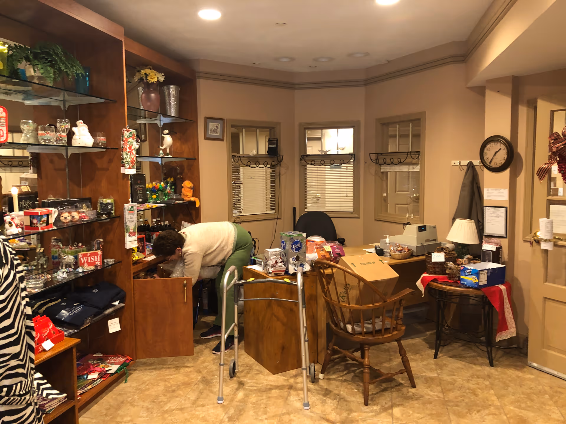 Indoor common area with gift shelves and a person by a cabinet.