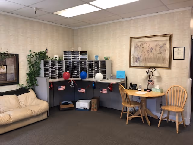 Interior common area with a sofa, mail slots, and a round table with chairs.
