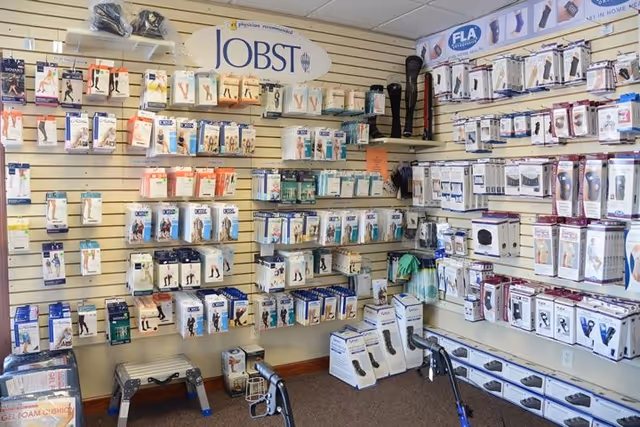 Interior display of medical stockings and braces arranged on wall shelves.