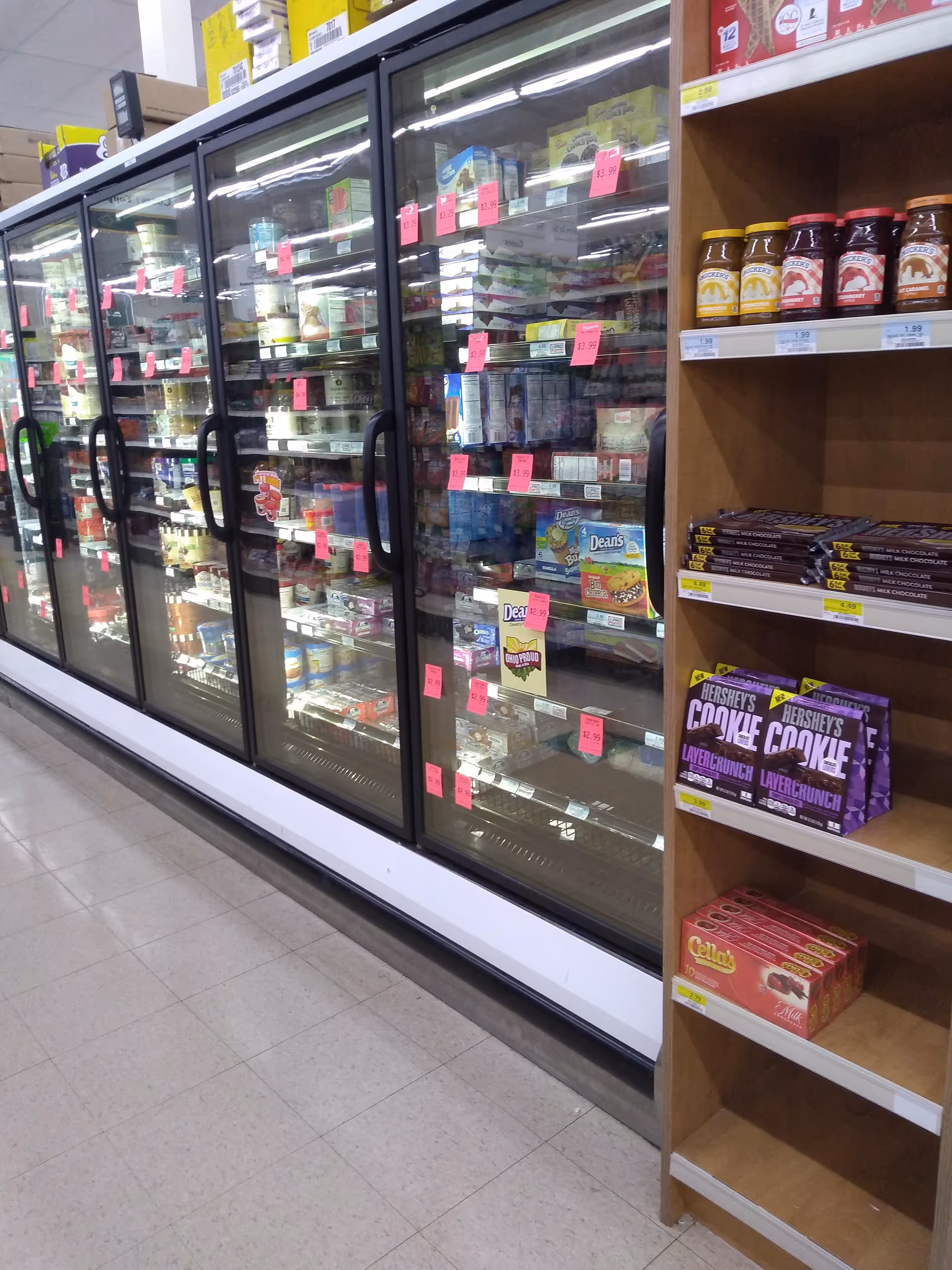 Interior view of a Discount Drug Mart aisle with glass-door freezers and stocked shelves.
