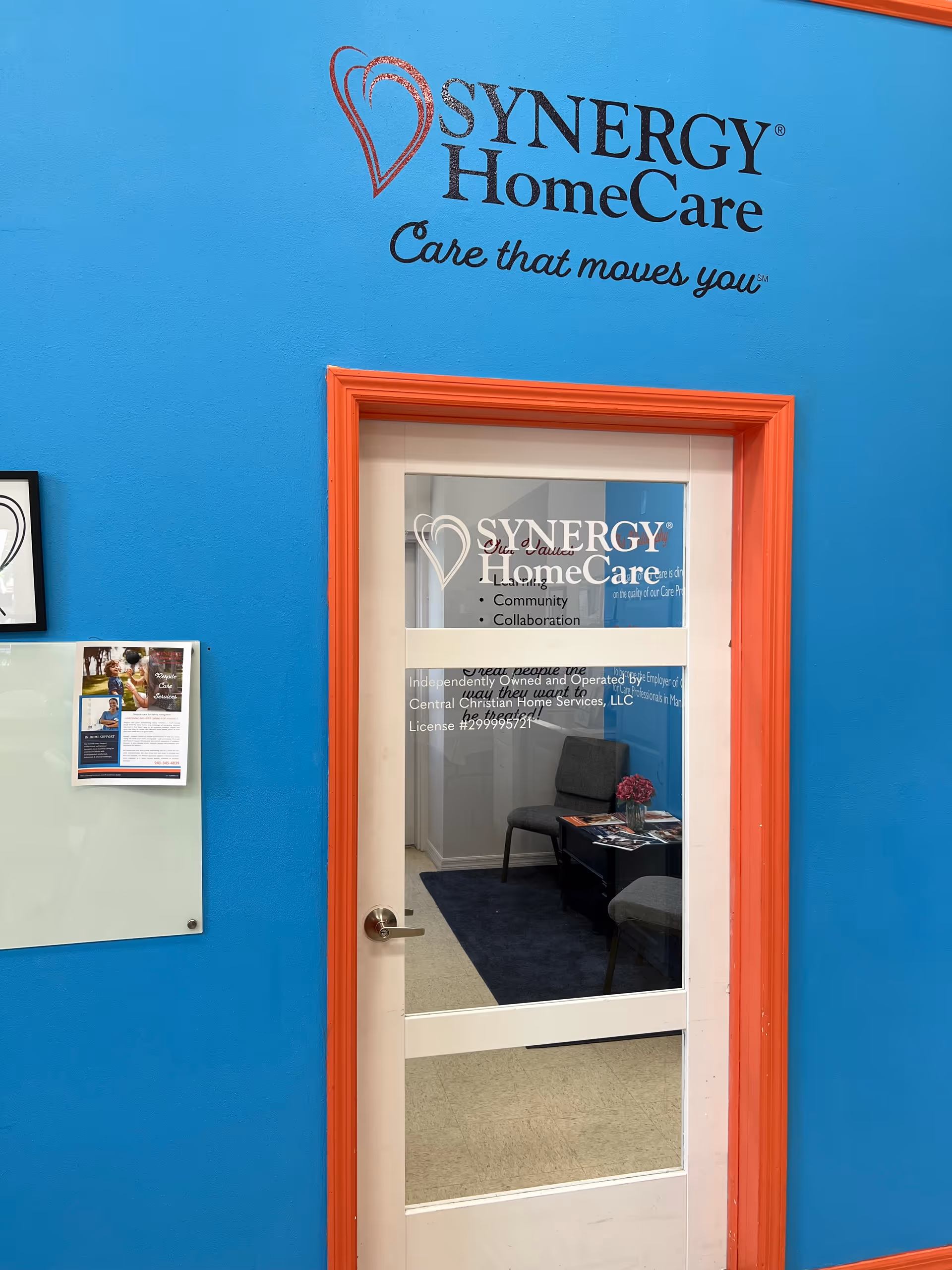 Bright blue wall with orange-trimmed glass door labeled Synergy HomeCare, interior seating visible.