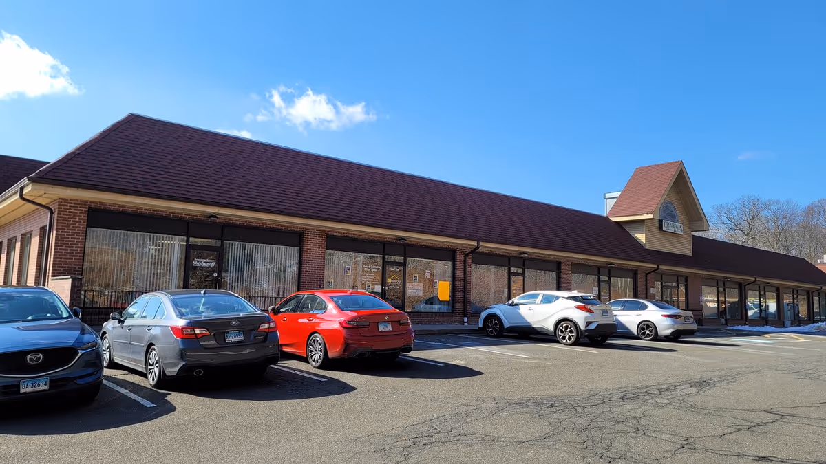 Front view of Comfort of Care Home Care building with parked cars.