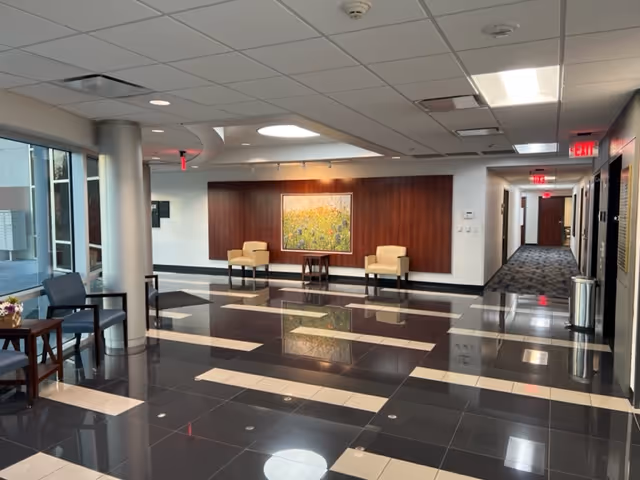 Bright lobby area with tiled floor, seating, and a hallway in Amenity Health Services PLLC.