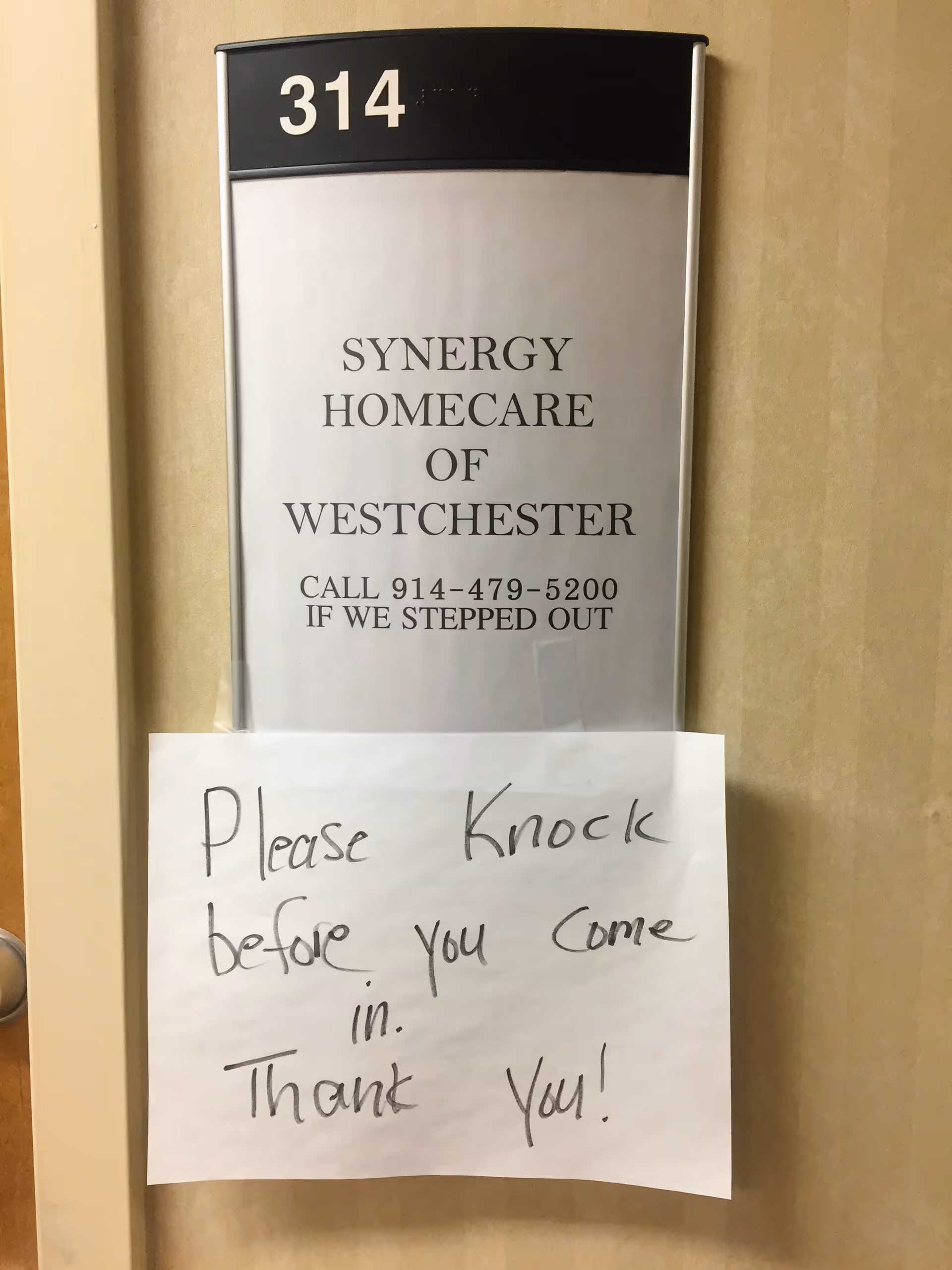 Door plaque reads Synergy HomeCare of Westchester; handwritten please knock before you come in.