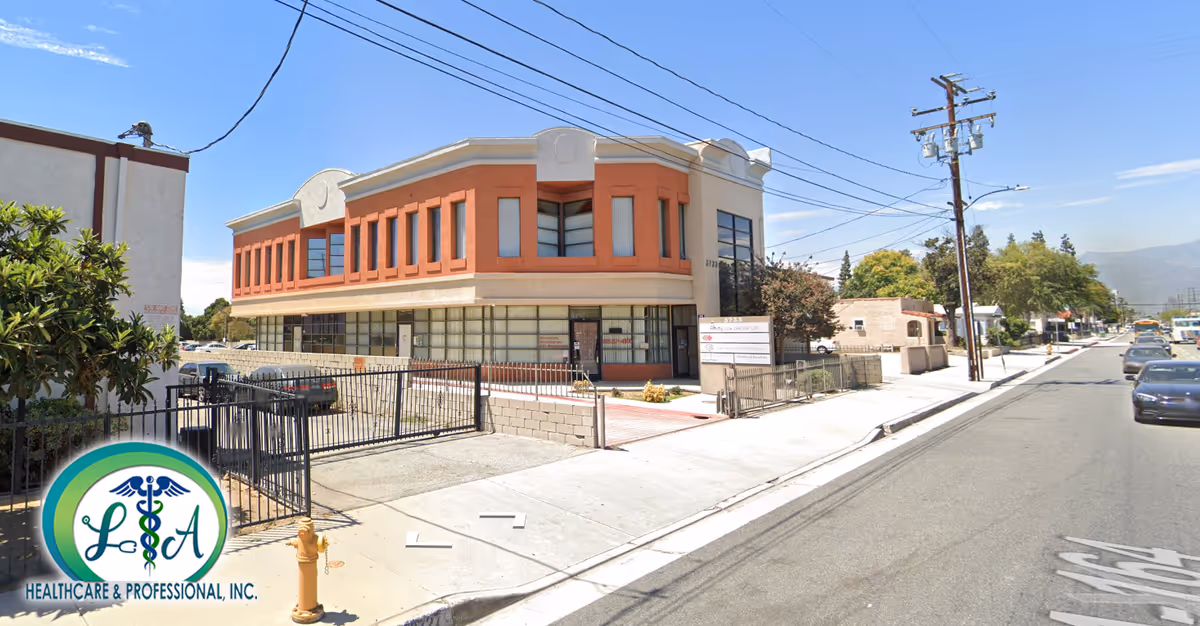 Exterior view of LA Healthcare & Professional, Inc. facility along sunny street with gated entrance.