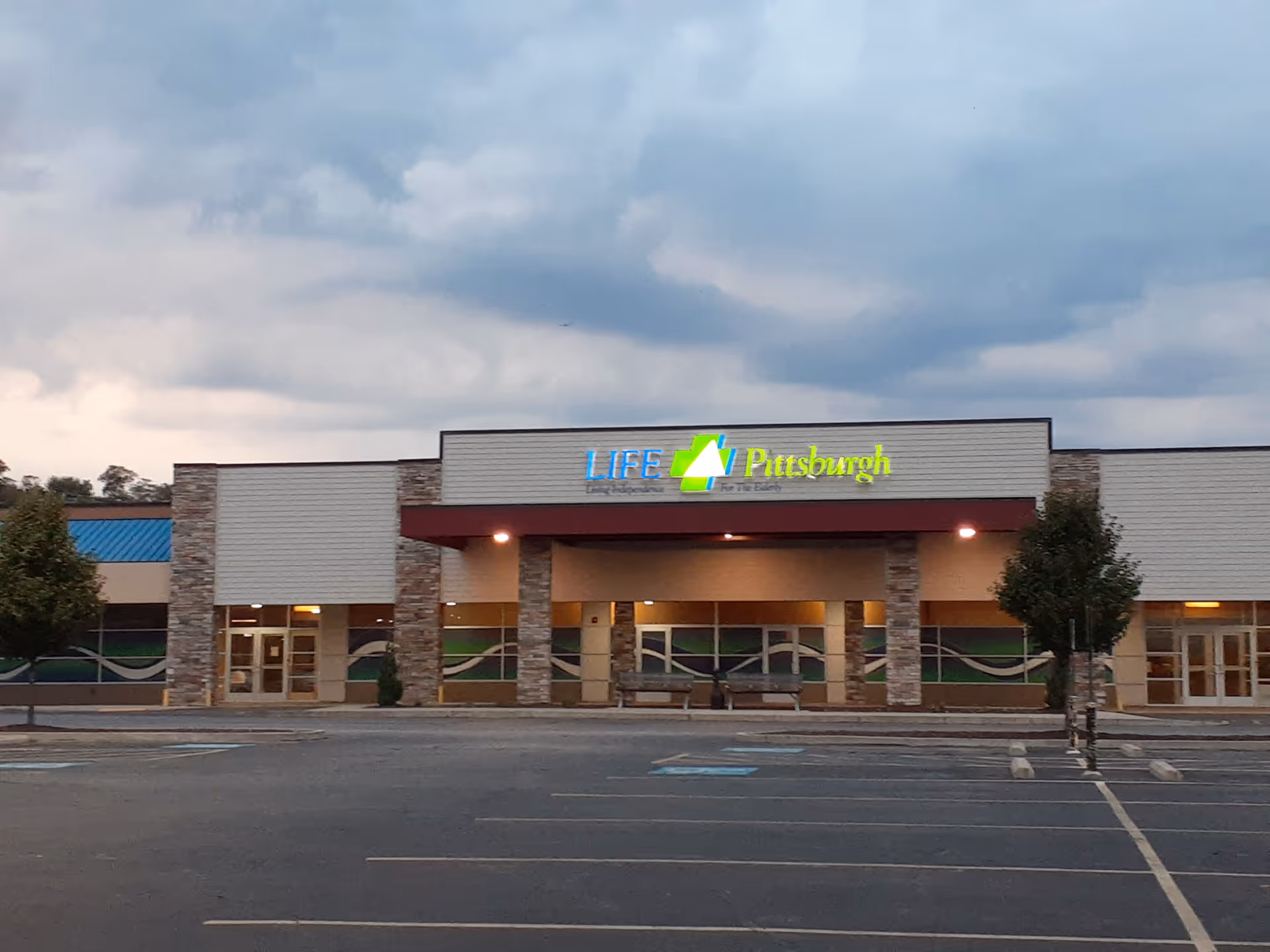 Front view of LIFE Pittsburgh building with entrance, signage, and empty parking lot.