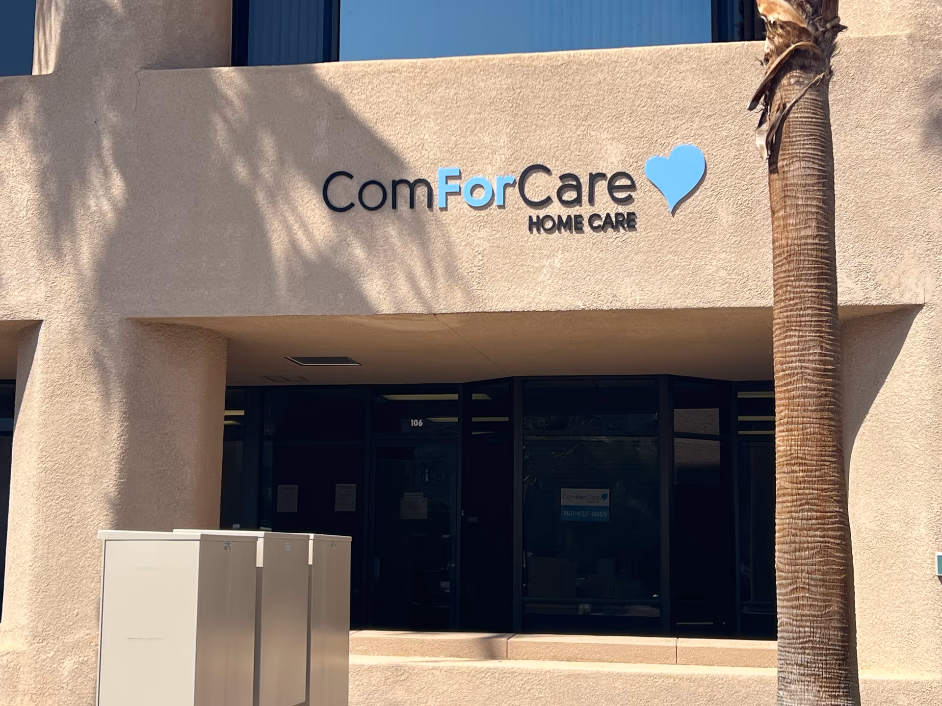 Facade of ComForCare Home Care facility with entrance doors and palm tree.