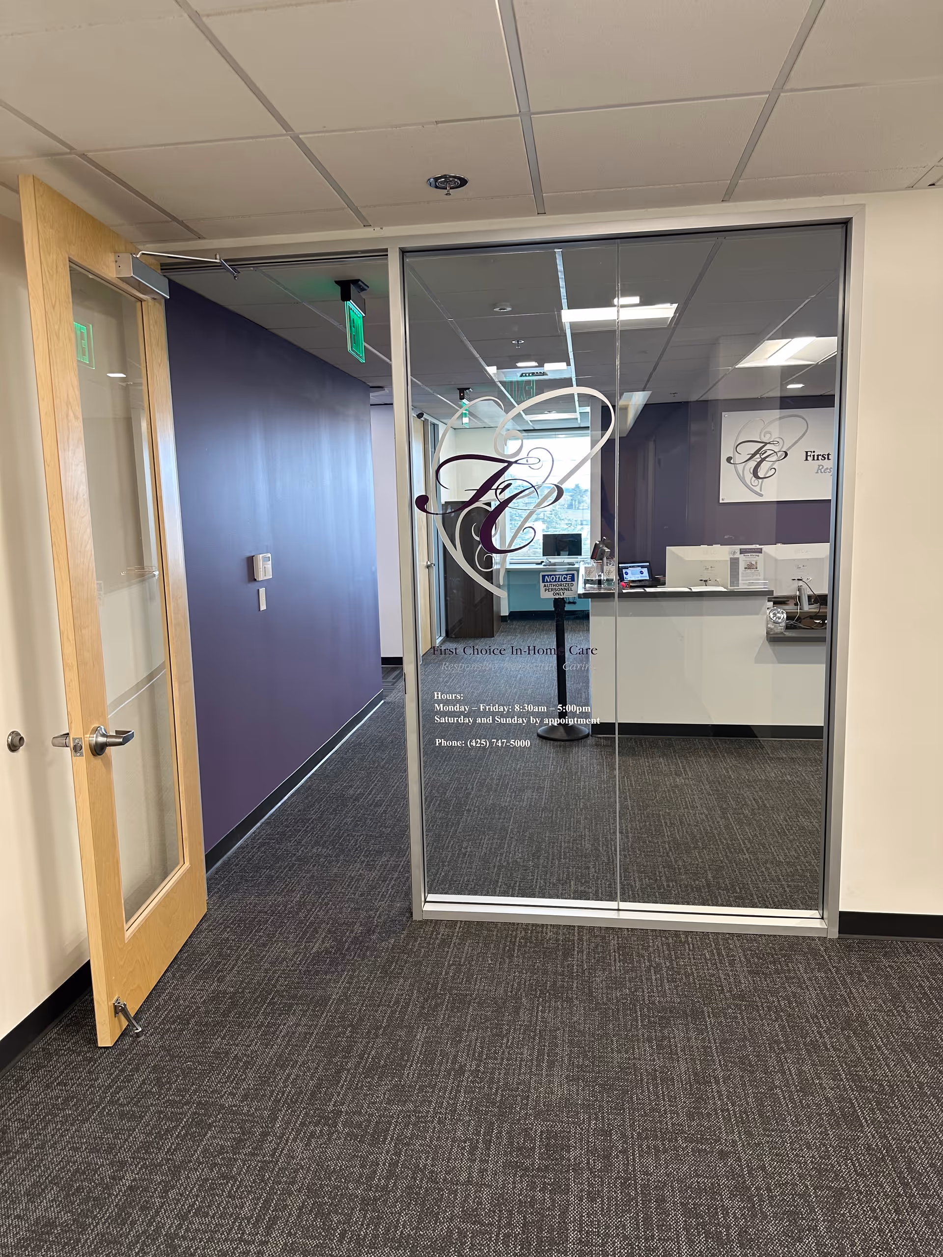 Interior lobby of a senior care facility with glass doors, purple walls, and a reception desk.