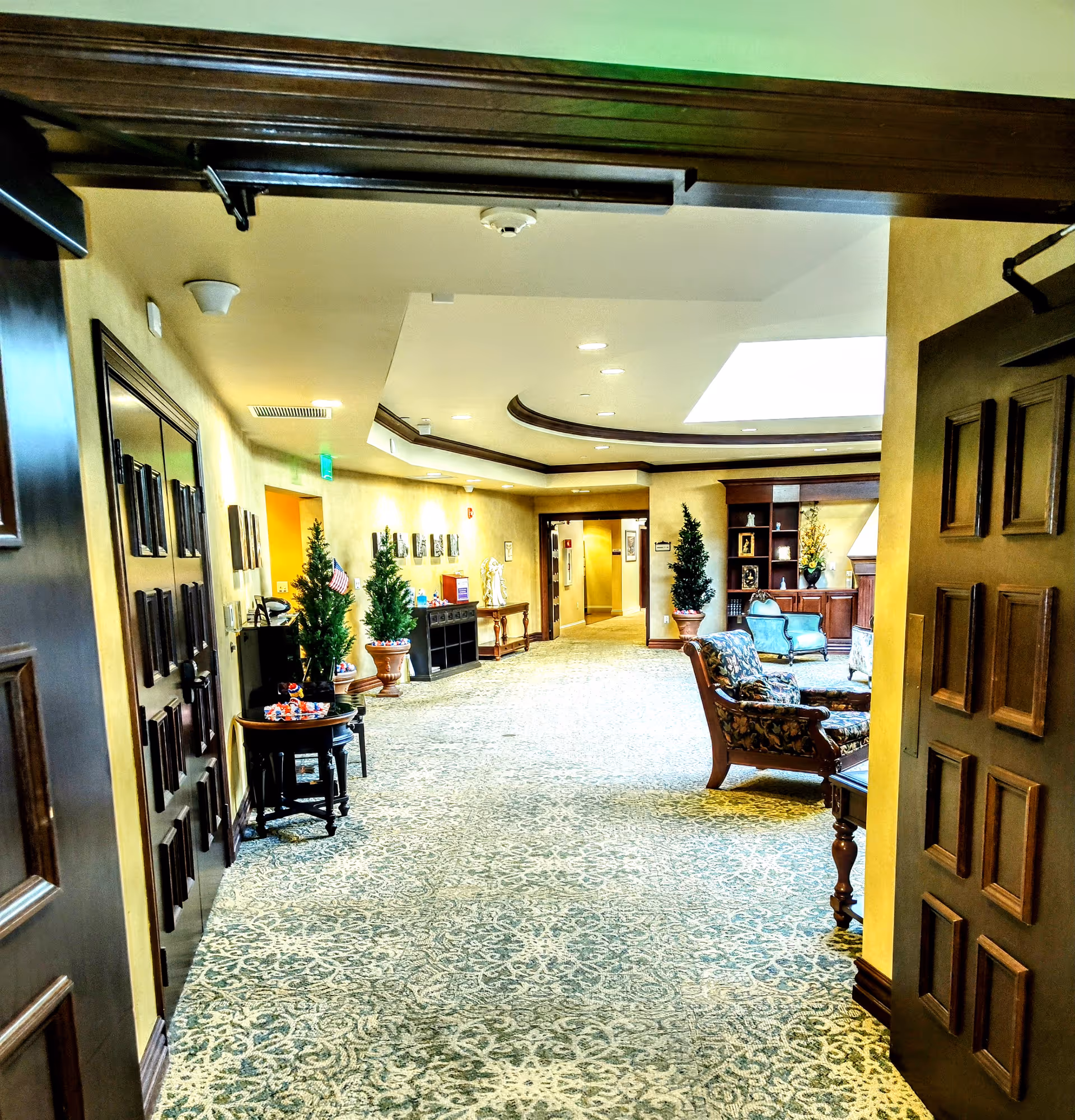 Elegant interior hallway at Gulfside Healthcare Services with seating areas and potted plants.