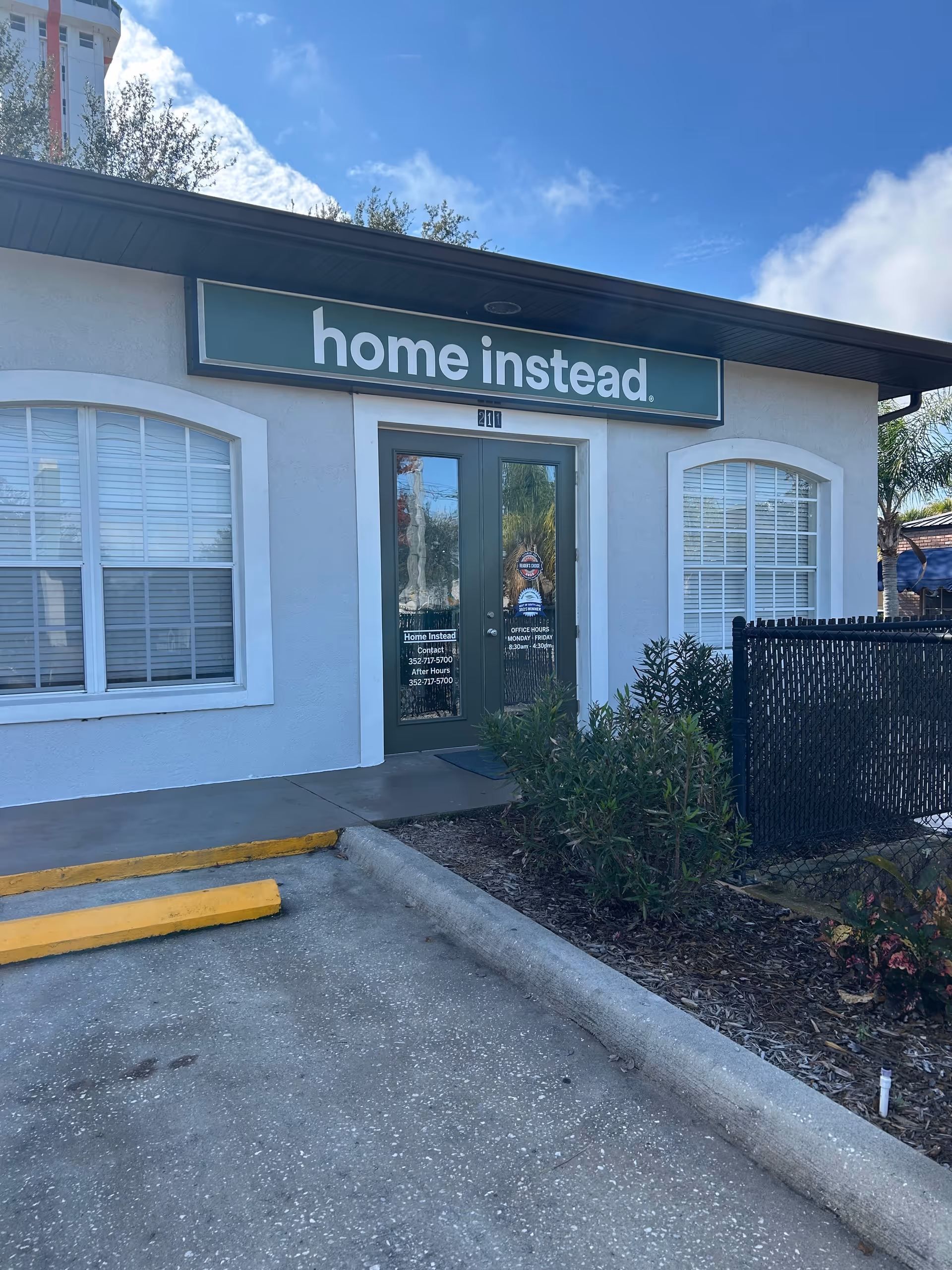 Exterior view of a Home Instead facility with sign and double doors at the entrance