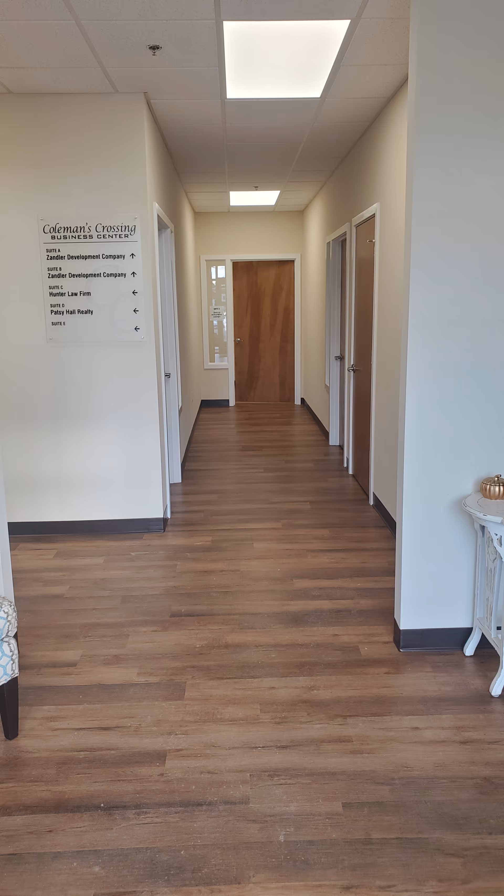 Long, well-lit hallway in a senior living facility with doors on both sides.