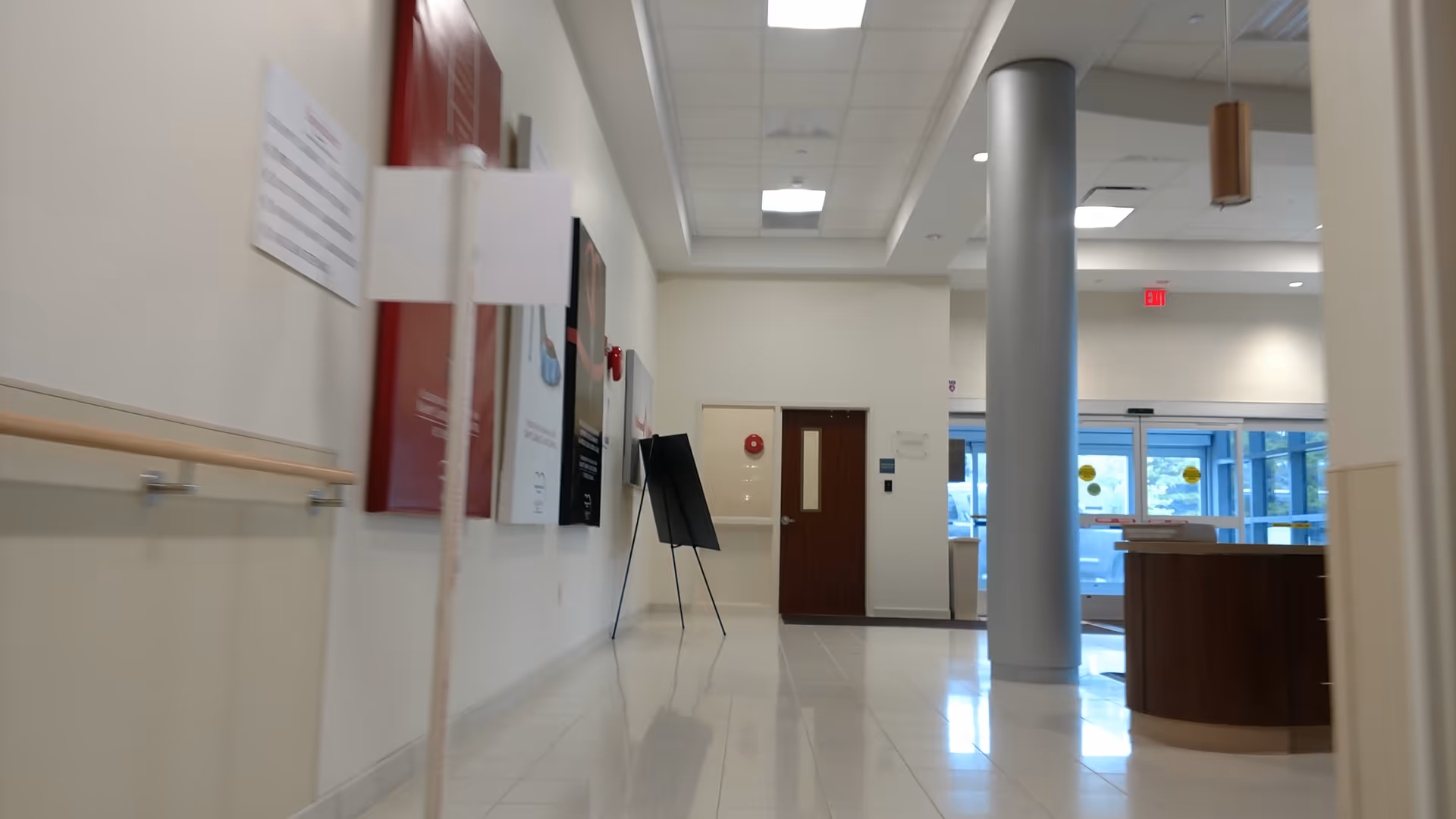 Long hallway in a senior living facility with a reception desk and pillar.