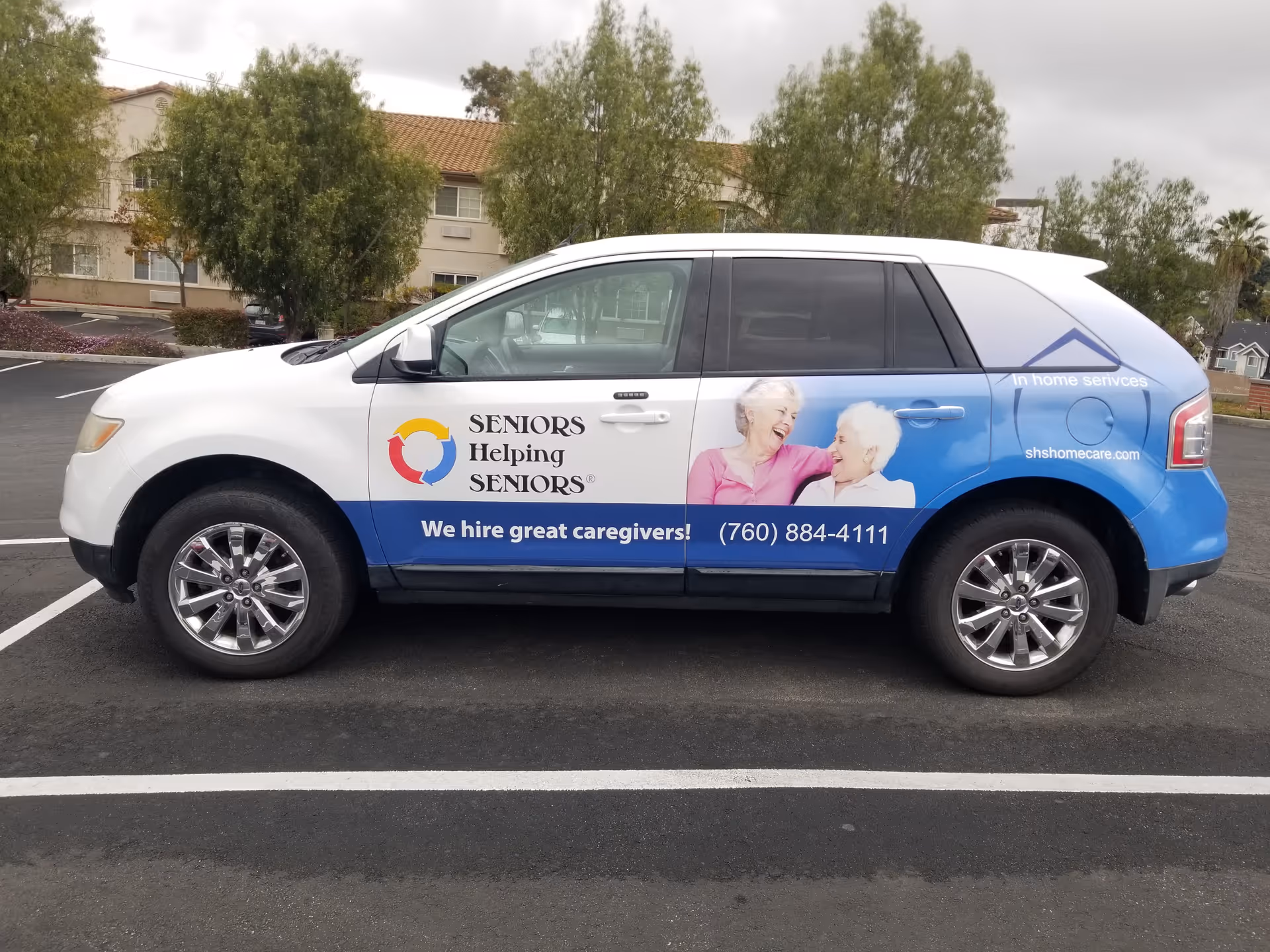 White and blue van with Seniors Helping Seniors branding and a smiling elderly couple image