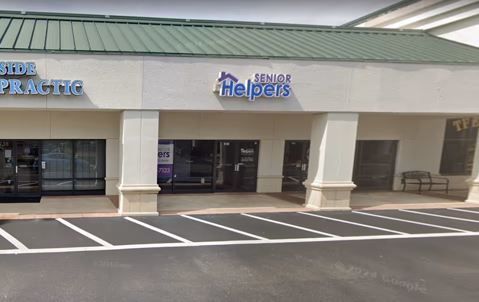 Exterior view of a strip mall storefront with a Senior Helpers sign.