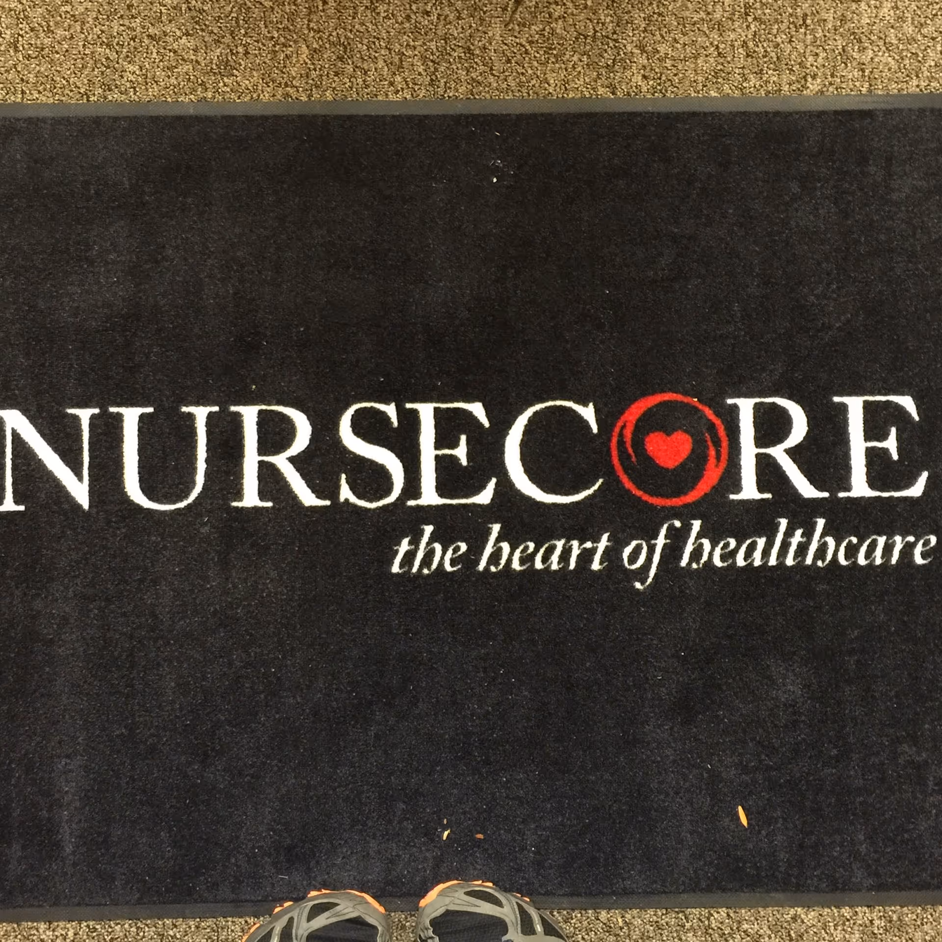Interior entry mat with NurseCore branding and a pair of shoes visible