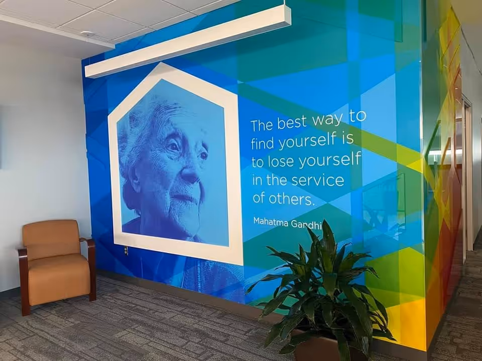 Colorful geometric mural featuring Mahatma Gandhi's quote in an interior hallway.
