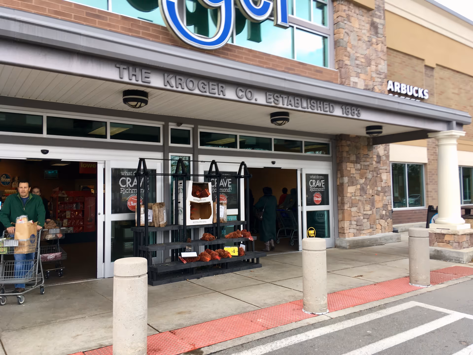 Kroger storefront with customers near the entrance and a pumpkin display.