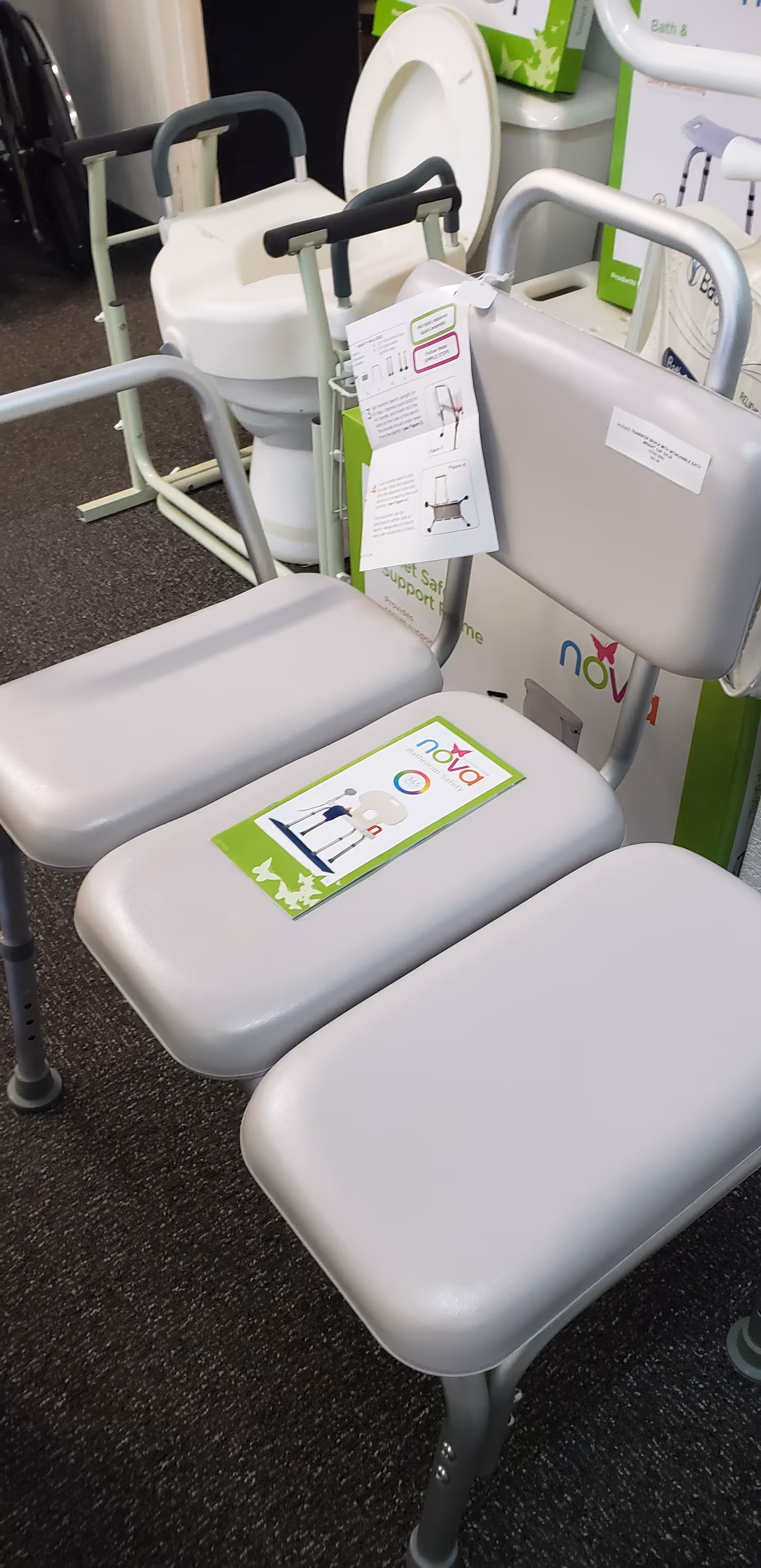 Assorted gray mobility chairs and a toilet display sit inside a retail showroom.