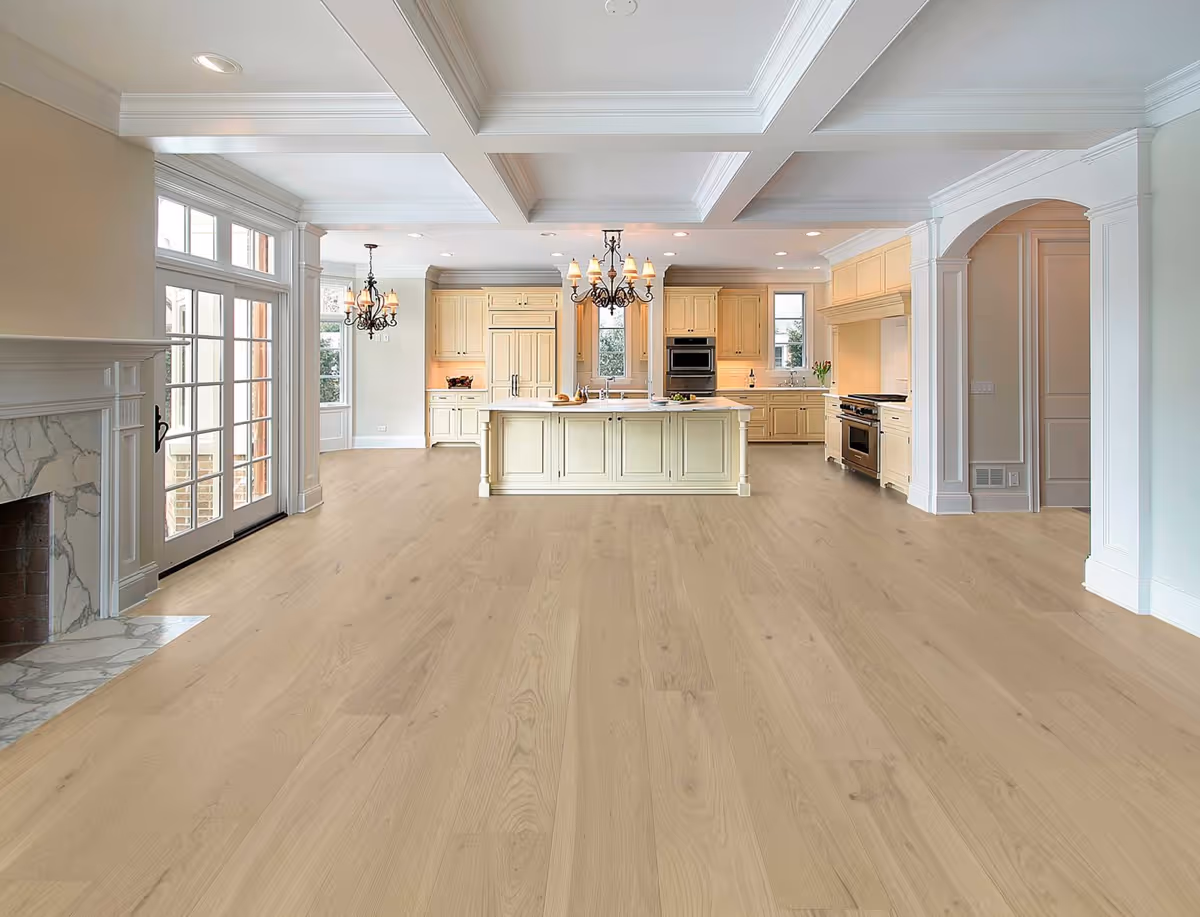 Bright open-plan kitchen with a large island, light cabinets, and chandeliers.