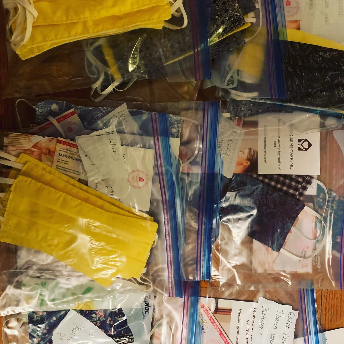 Close-up of Ziploc bags containing masks, papers, and notes on a table.