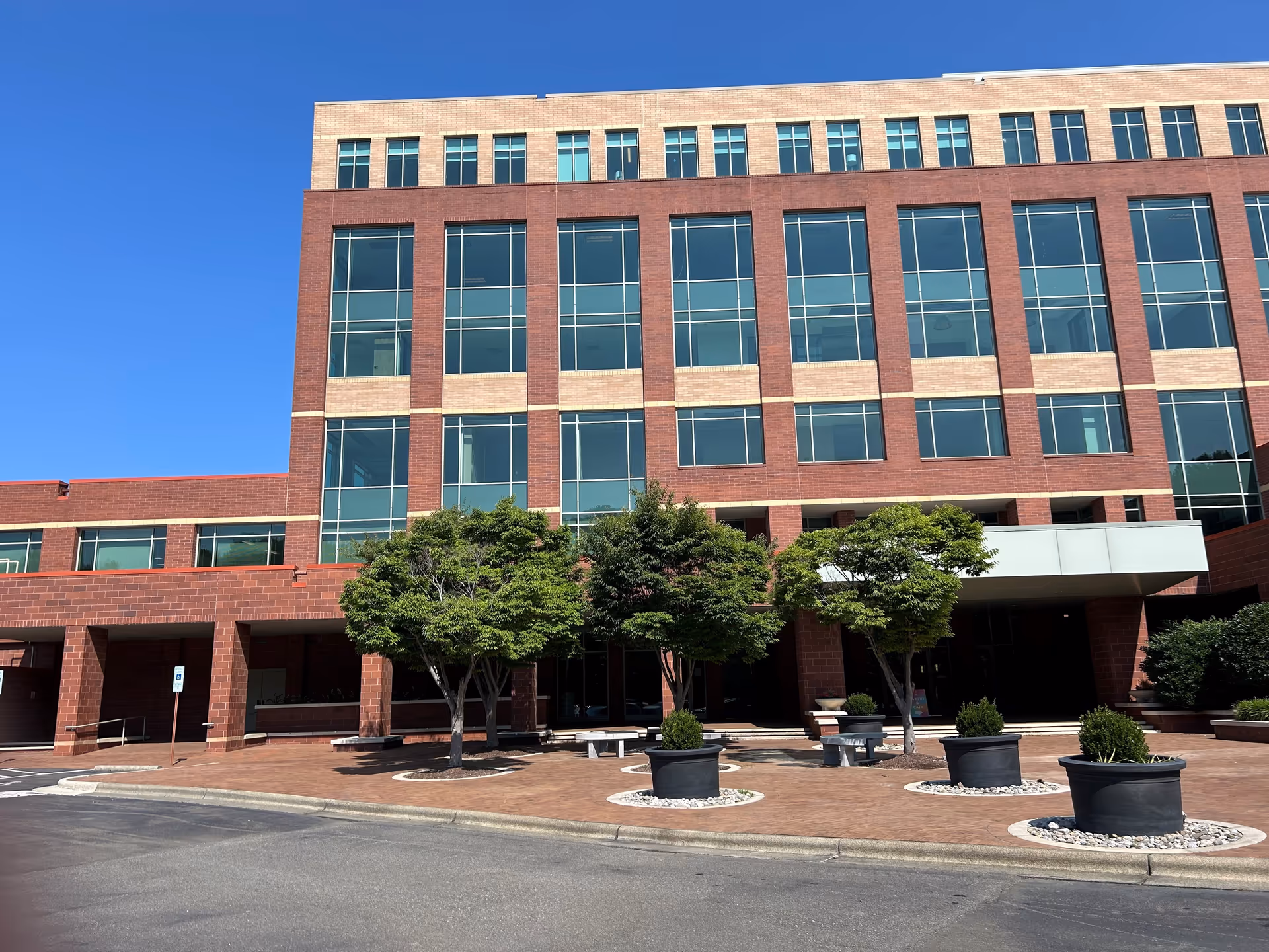 Exterior view of BAYADA Assistive Care building with brick facade and trees in front.