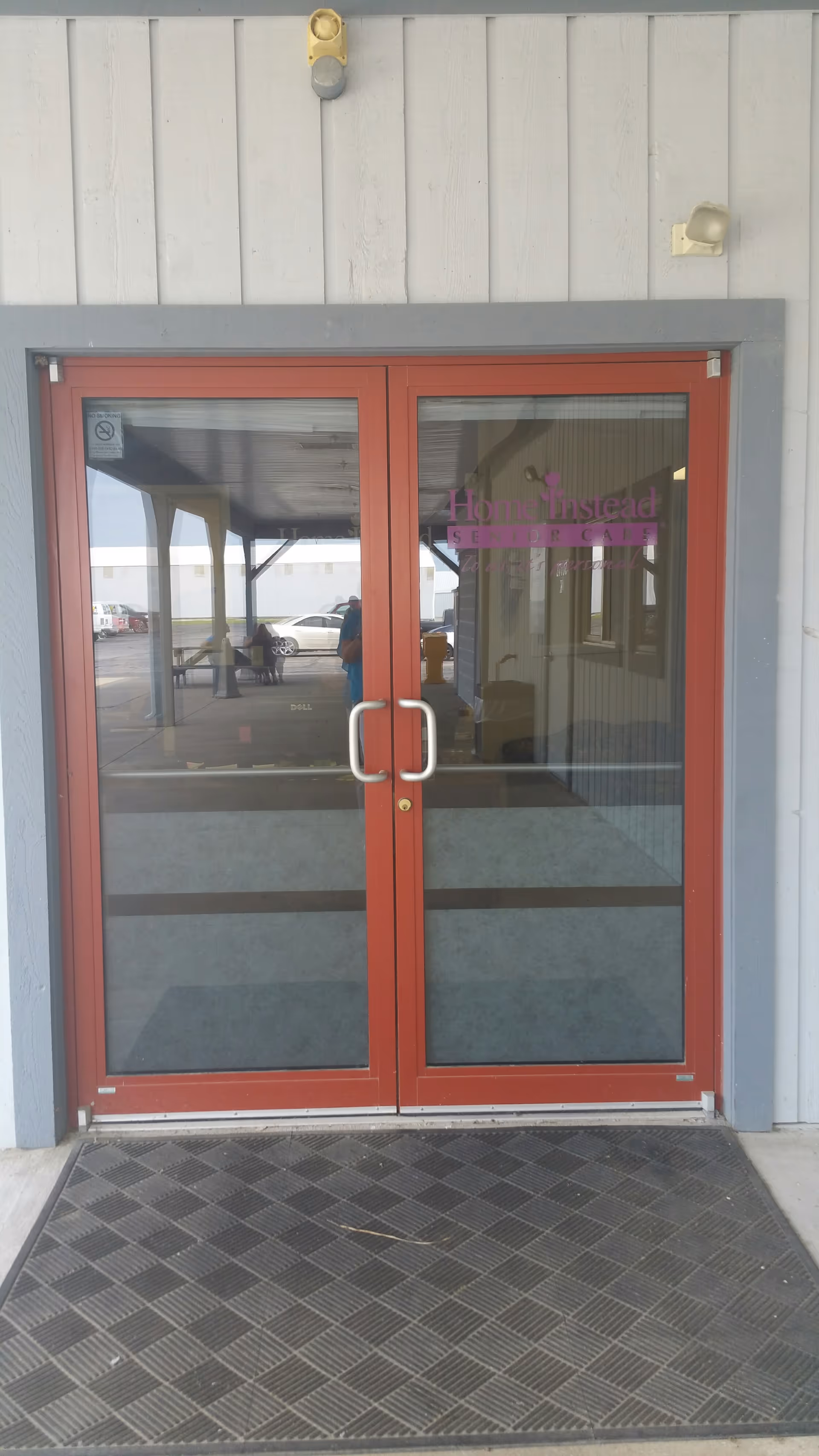 Front entrance with red-framed glass doors at Home Instead senior facility.