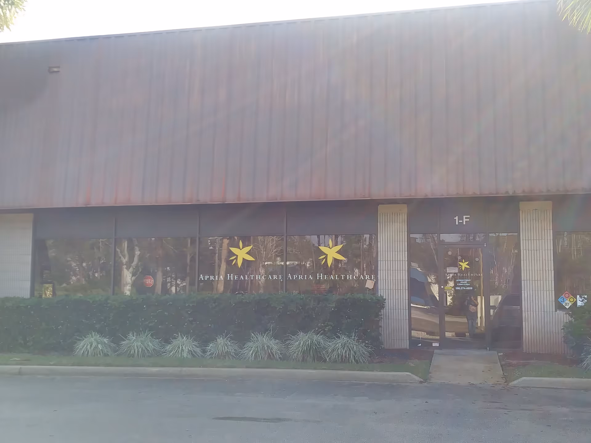 Exterior view of Apria Healthcare building with glass doors and signage.