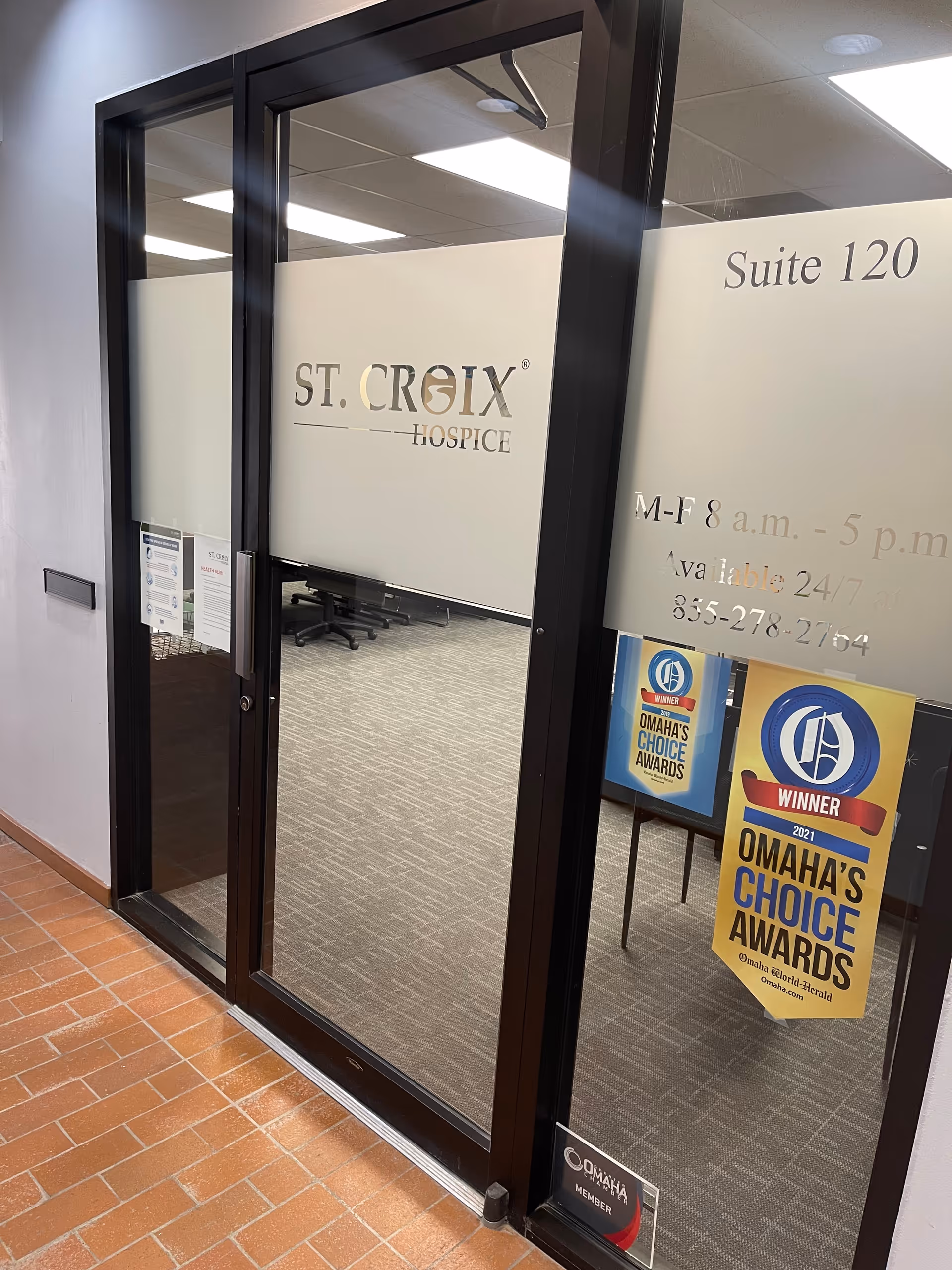 Glass-framed office door for St. Croix Hospice suite with awards banners visible