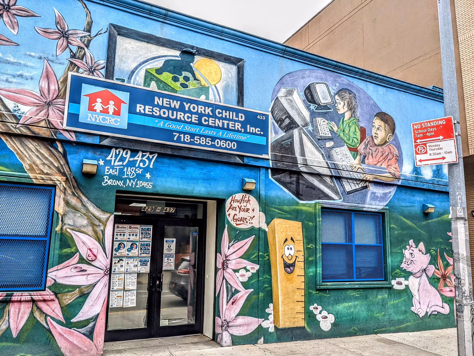 Exterior of a mural-covered building with a blue sign for New York Child Resource Center, Inc.