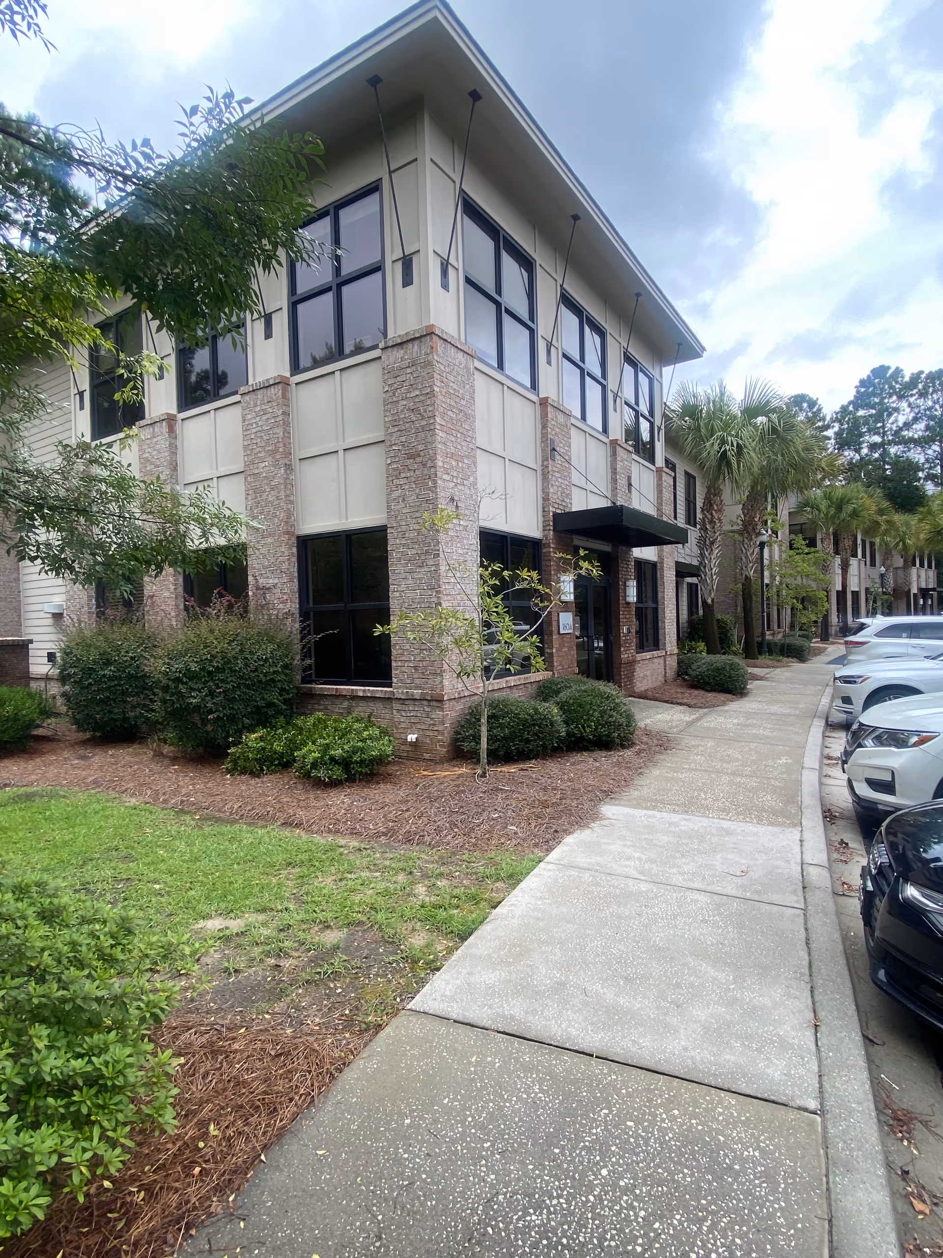 Exterior view of a BrightStar Care building with brick columns and a sidewalk.