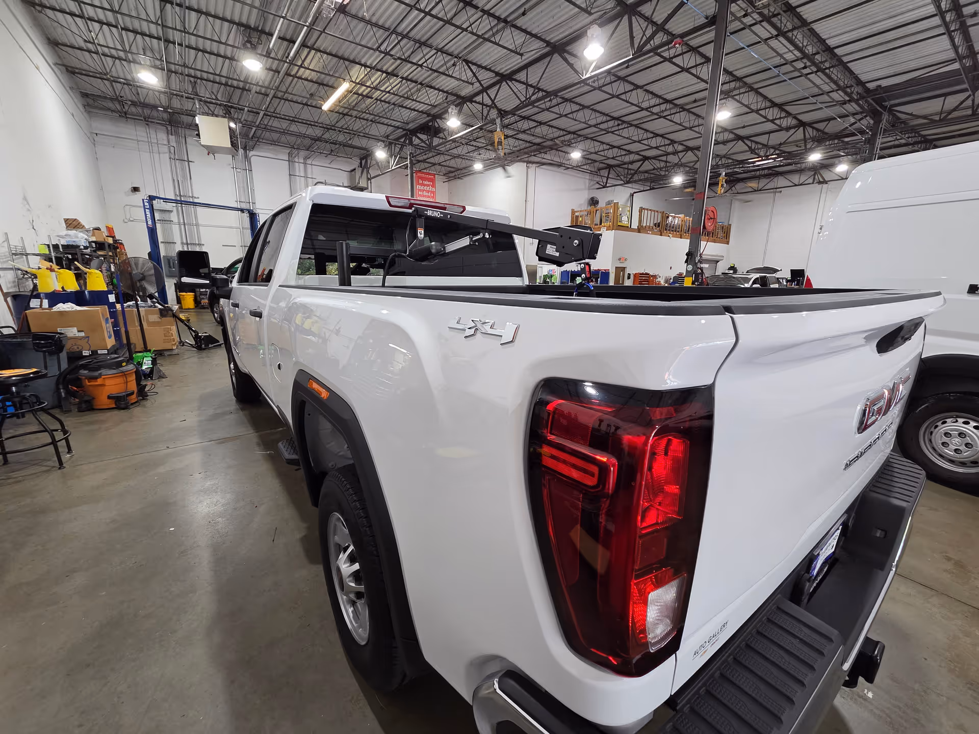 White pickup truck inside a busy workshop filled with tools