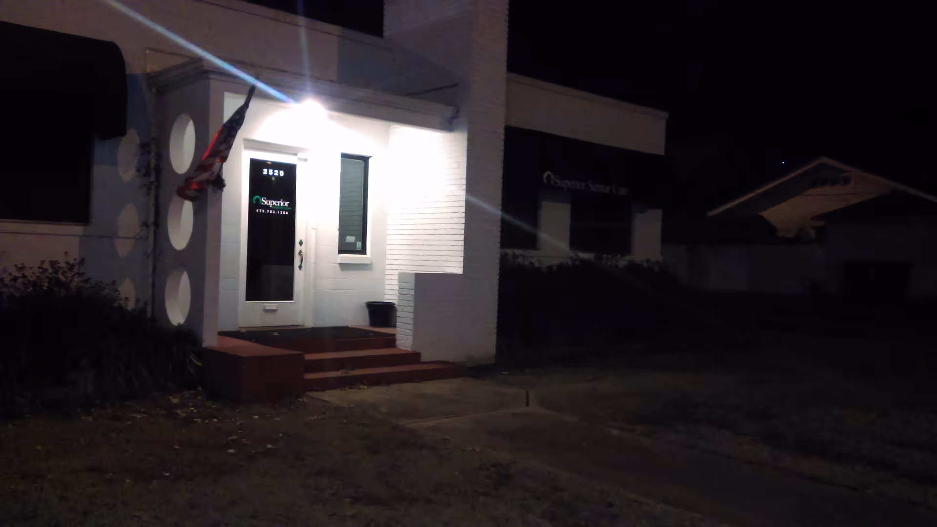 Night exterior of Superior Senior Care building with illuminated entrance and steps