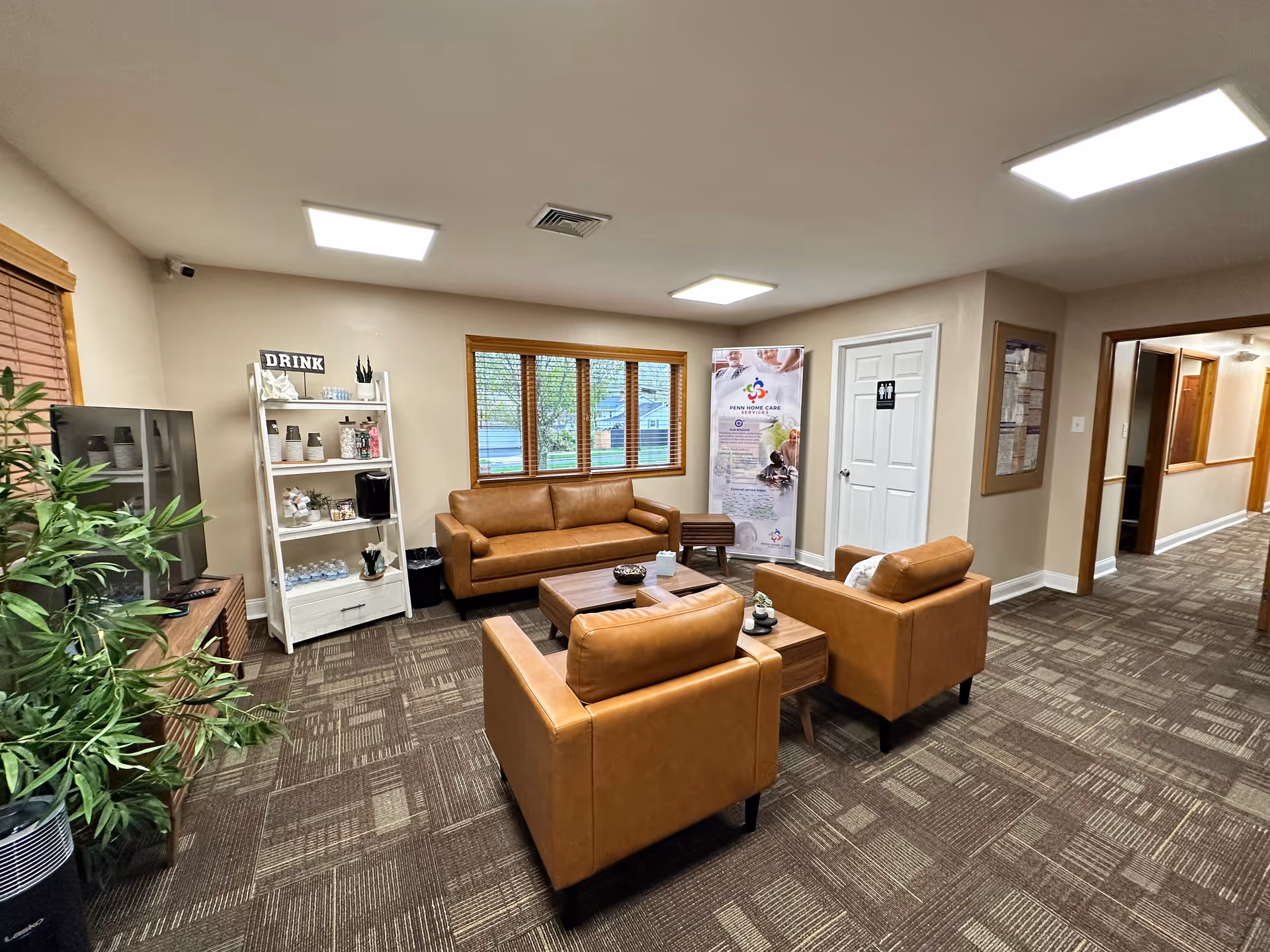 A cozy lounge area with brown leather couches, a coffee table, and a plant.