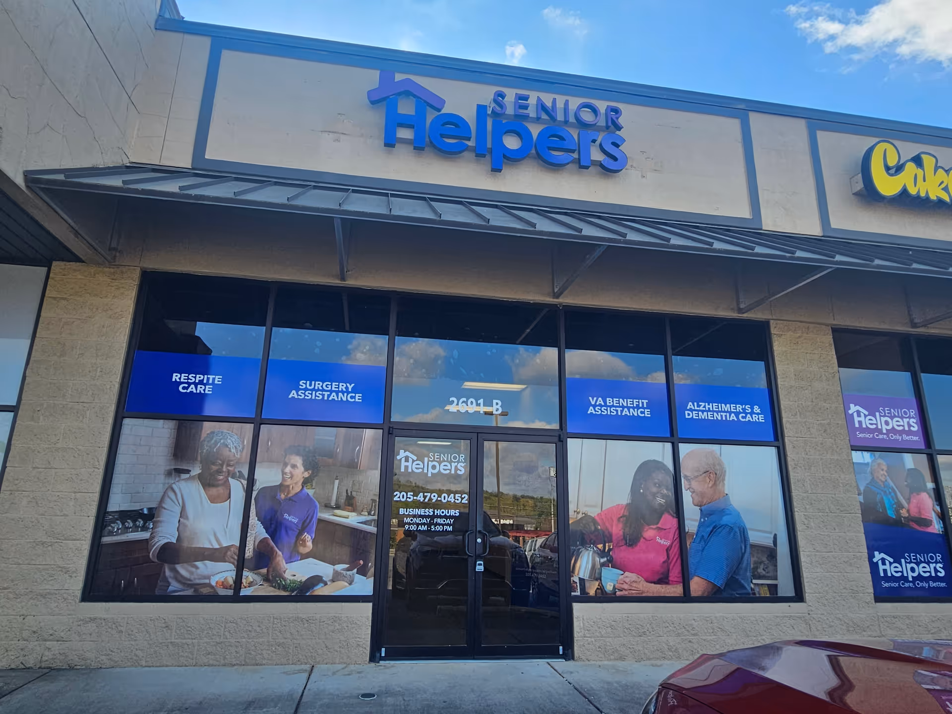 Senior Helpers storefront with blue signage, large windows, and promotional posters outside.