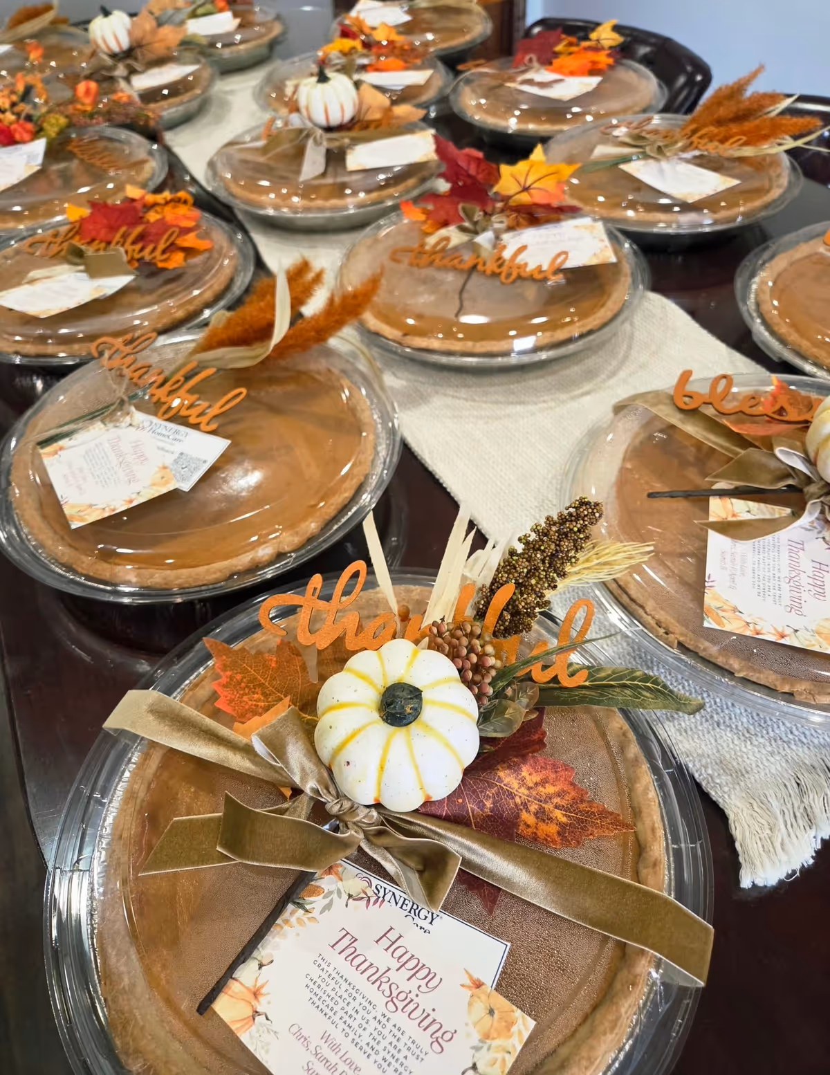 Dining table set with Thanksgiving plates, ribbons, pumpkins, and autumn decorations.