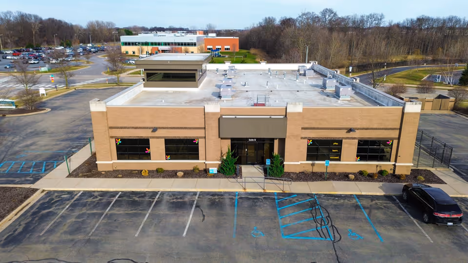 Aerial view of a single-story brick senior living facility with surrounding parking area
