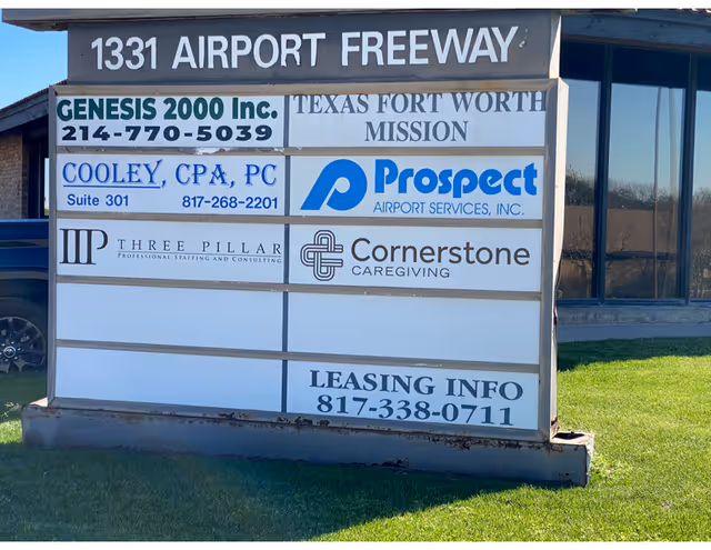 Outdoor signboard with multiple business signs, including Cornerstone Caregiving, in front of a building.