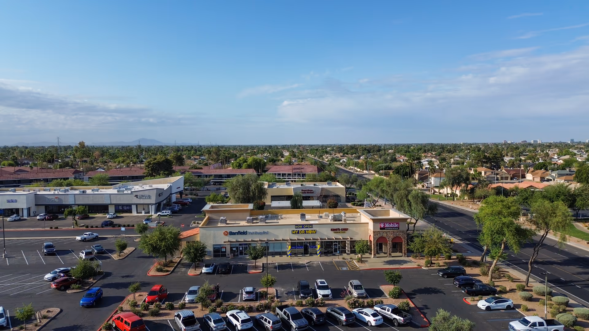 Aerial view of a shopping center with My Dr Now storefront and surrounding parking.