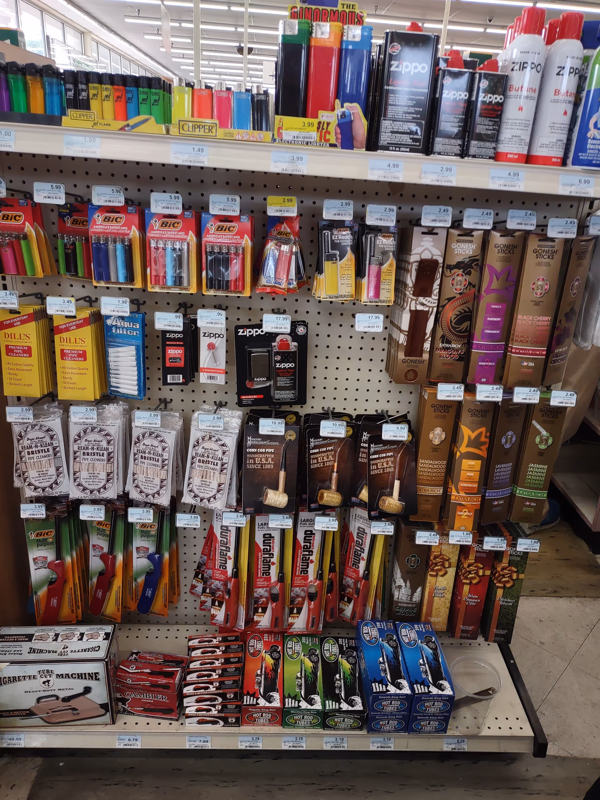 Store aisle filled with assorted lighters, razors, and grooming accessories on pegboard