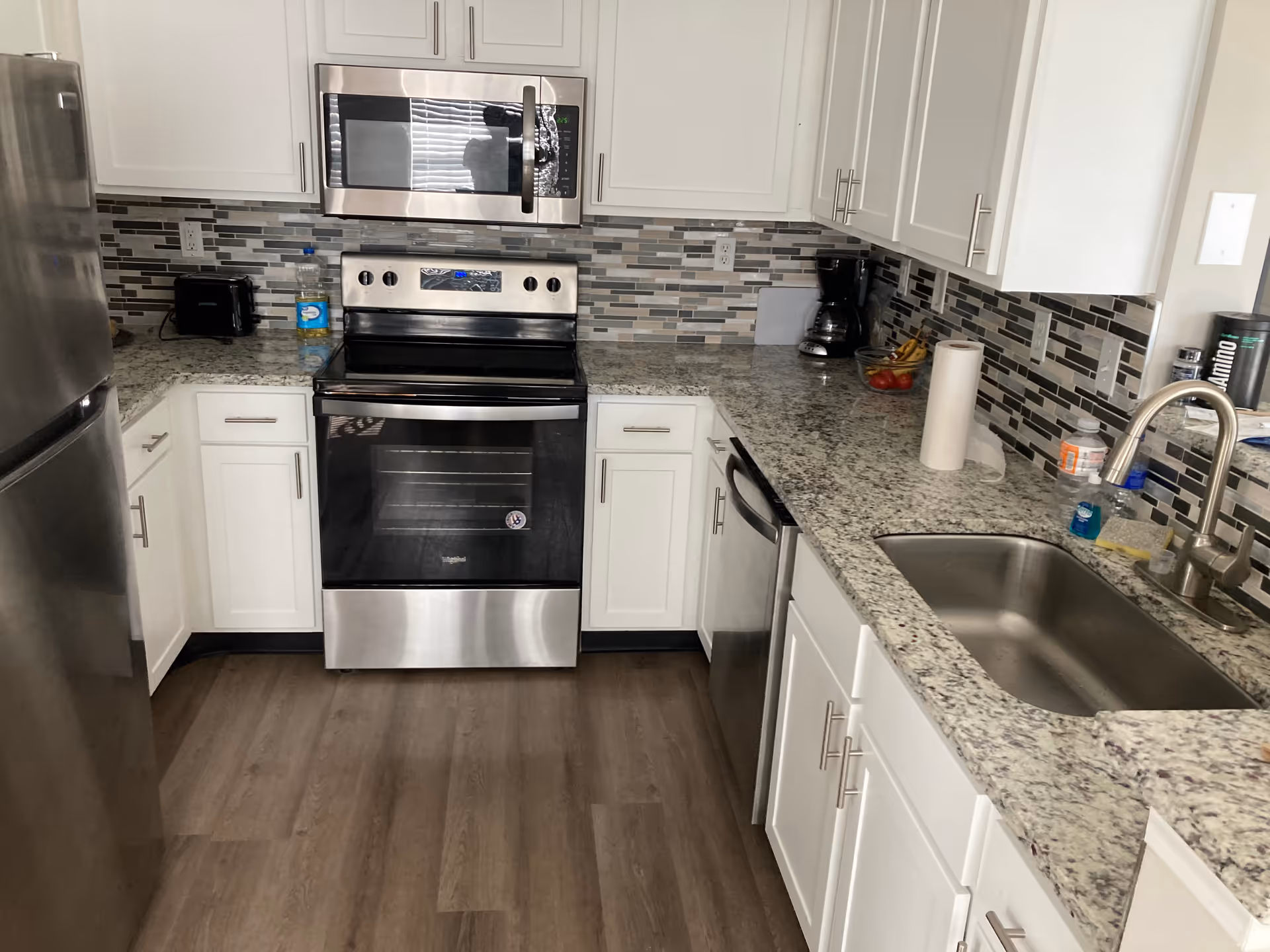 Bright modern kitchen with stainless steel appliances, granite countertops, and a double sink.